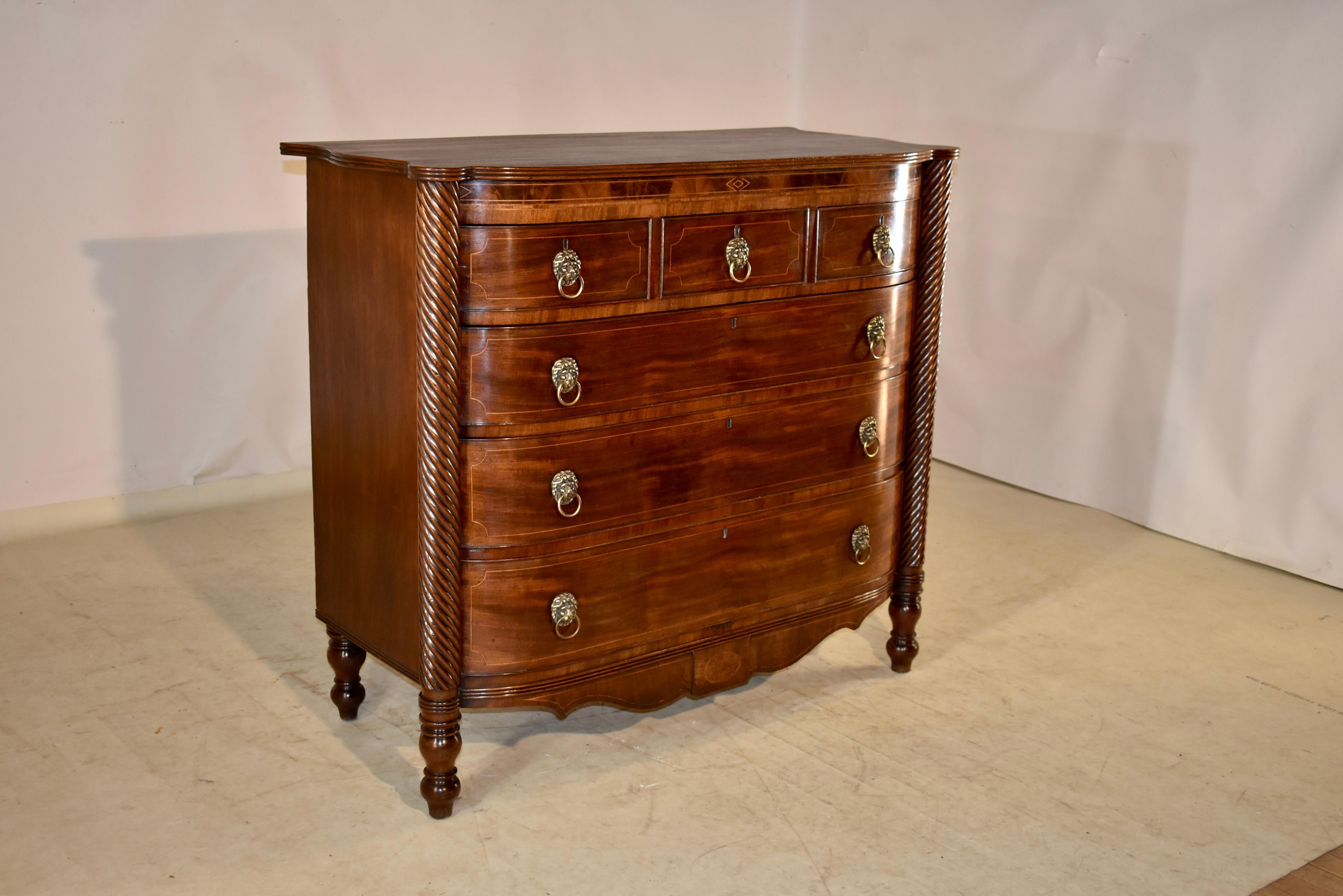 Early 19th century mahogany bow front chest of drawers from England. The top is made from a single plank, which features wonderful graining and scalloped edging, which also feature routed decoration. The case is simple on the sides, and are also