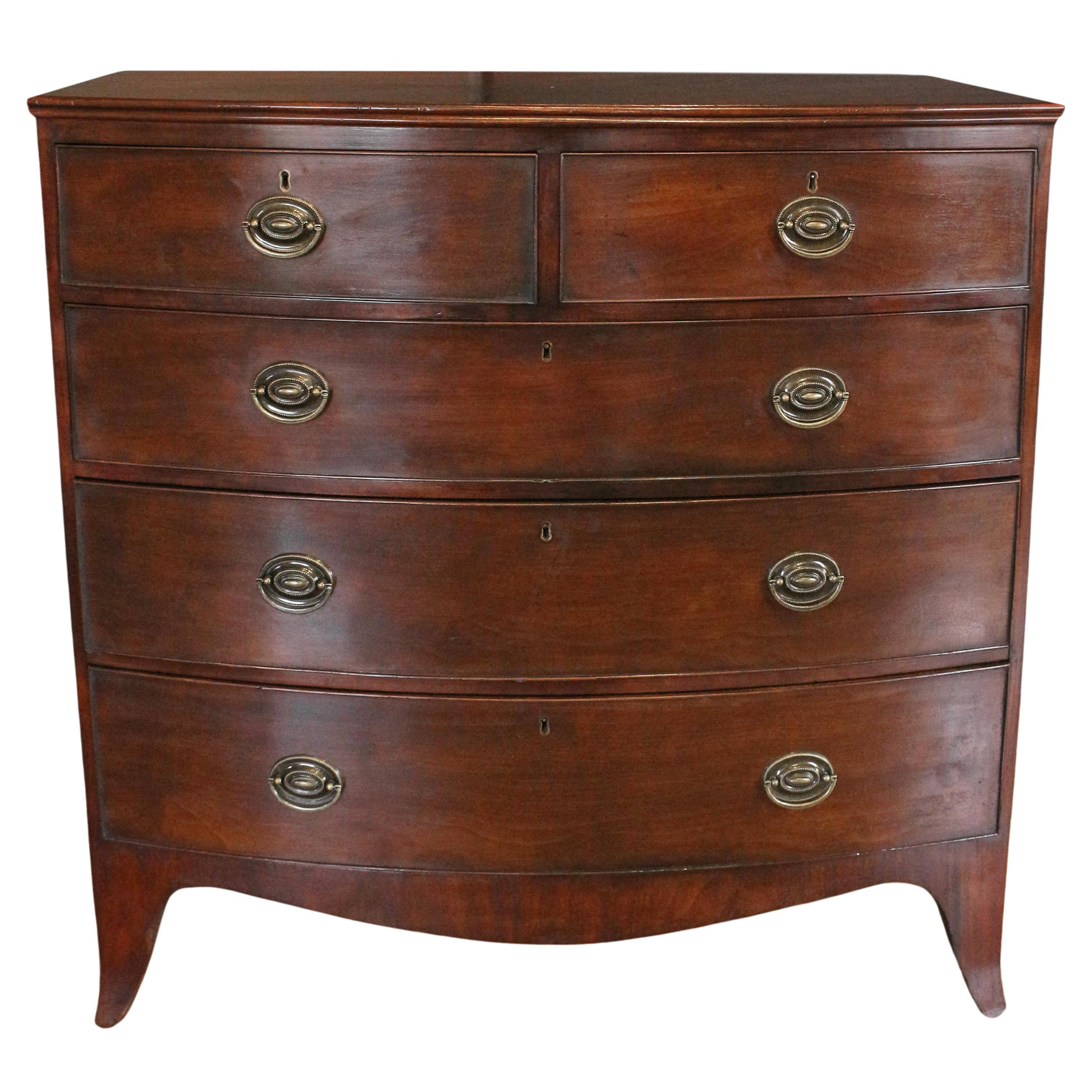 Early 19th century bowfront chest of drawers, English. Georgian period. Two short over 3 long graduated drawers. Raised on French splay feet. Double molded top. Oak secondary wood. Appropriately replaced oval brass pulls.
41 3/8