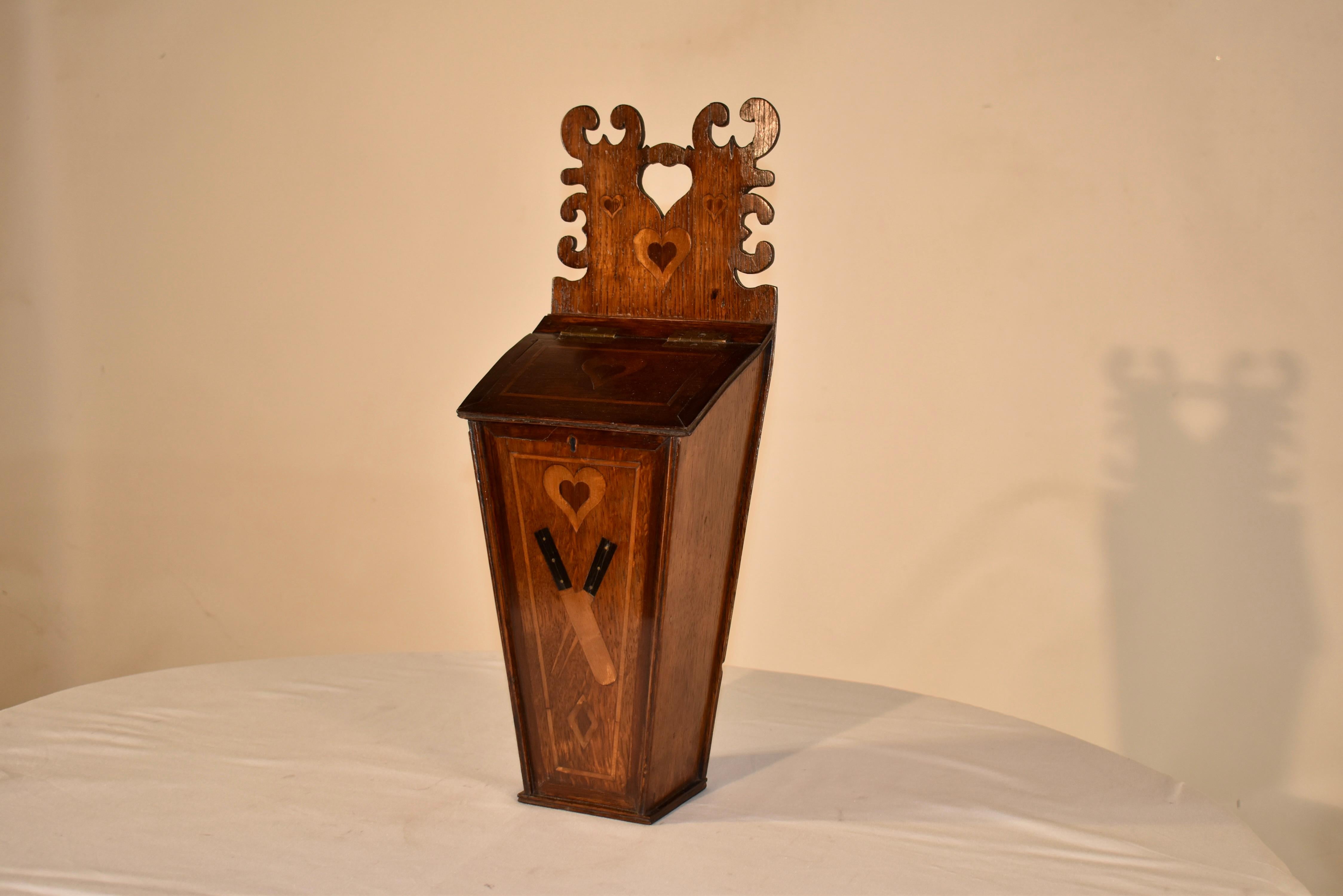 Early 19th century oak candle box from England.  This is a wonderful folk art box with loads of character!  The top of the box is hand carved and has wonderful scalloped shapes and a central heart, surrounded by inlaid hears for added whimsy.  The