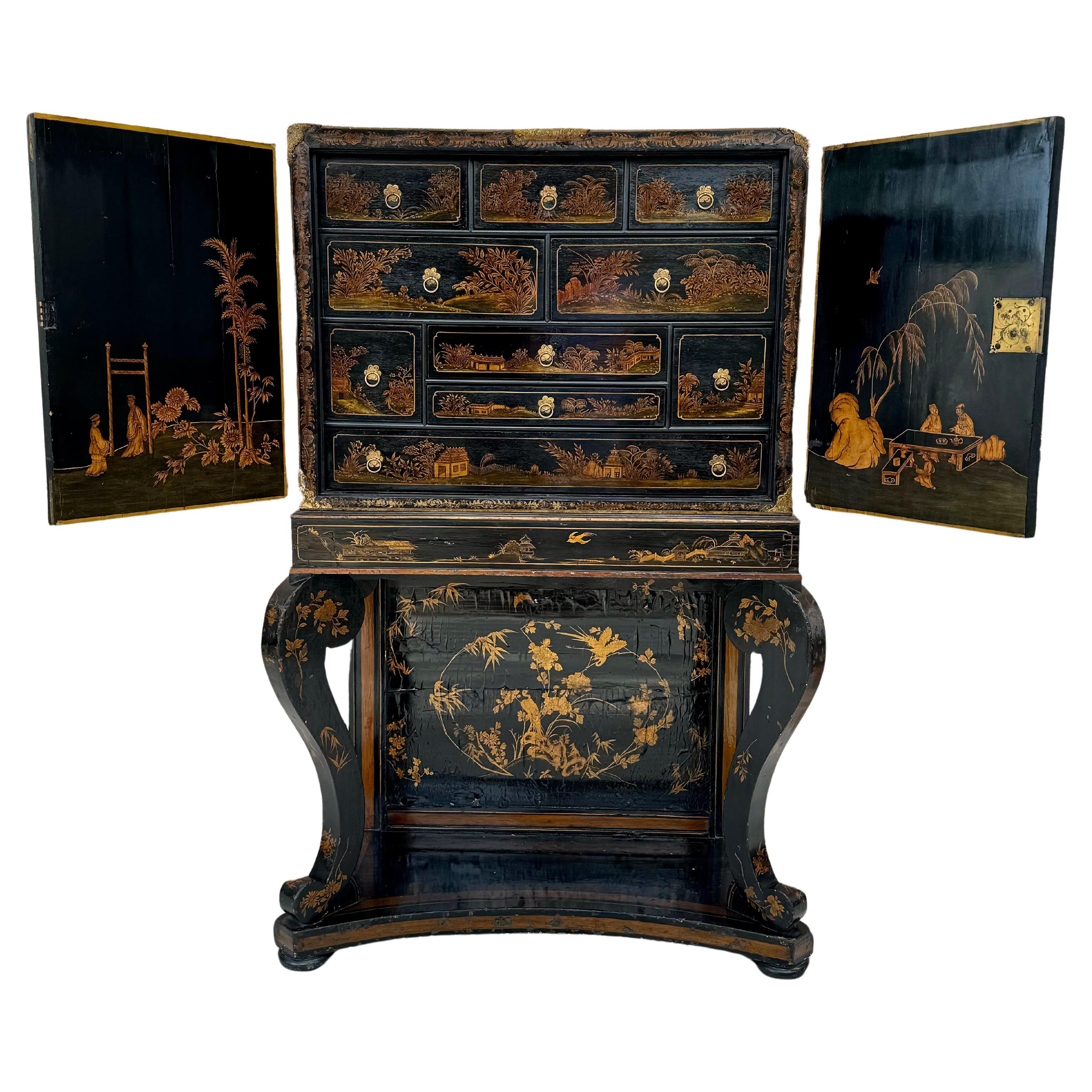 Rare Late 18th or Early 19th Century English Regency Chinoiserie chest on stand with Japanned lacquered finish in black and gold. This cabinet has two doors with scenic Chinoiserie decoration both on the exterior and interior, open to a concealed