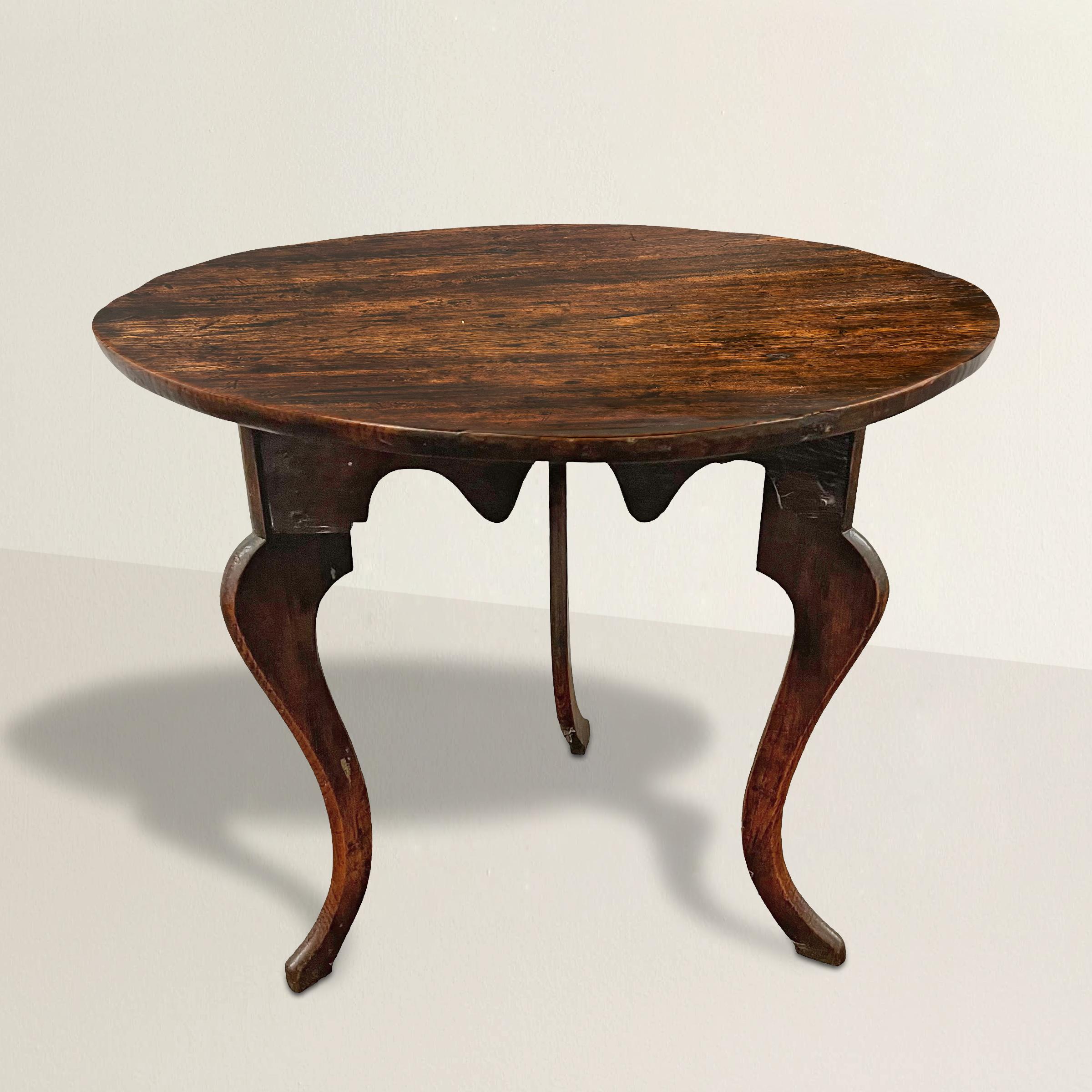 Step into the elegance of 19th-century England with this exquisite cricket table, a true testament to the craftsmanship of the era. Adorned with cabriole legs and a 