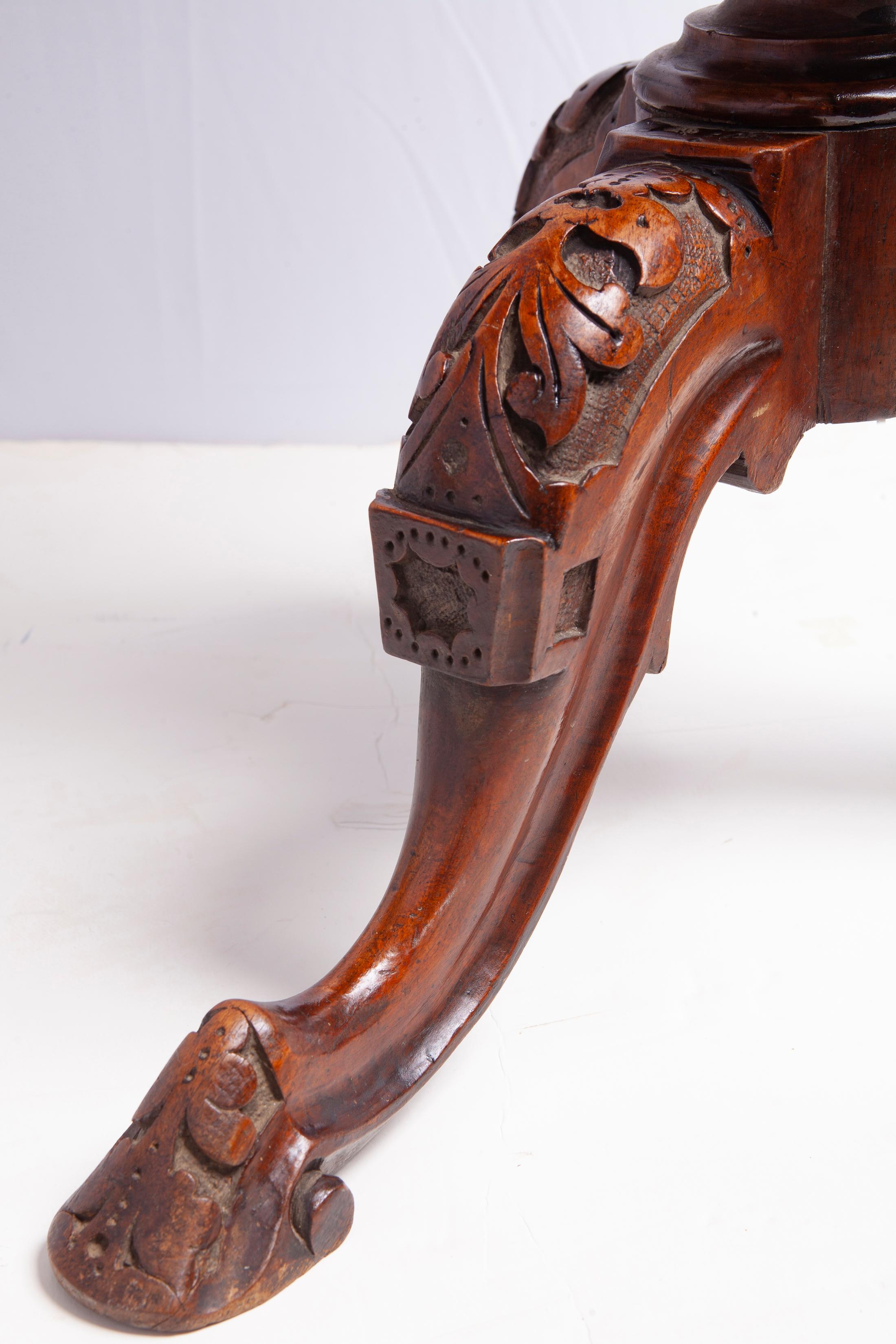 Antiker englischer runder Beistelltisch mit rustikaler Intarsienarbeit. Der Tisch hat detaillierte Schnitzereien an den Beinen und am Sockel.