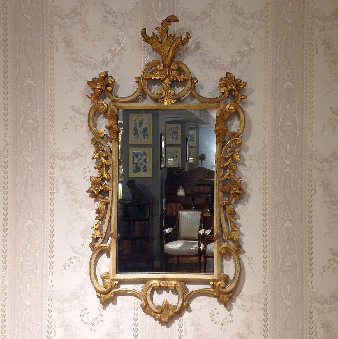 This exquisite George III gilt and painted rococo mirror is ornamented throughout with finely carved C-scrolls, acanthus leaves, and flowers.