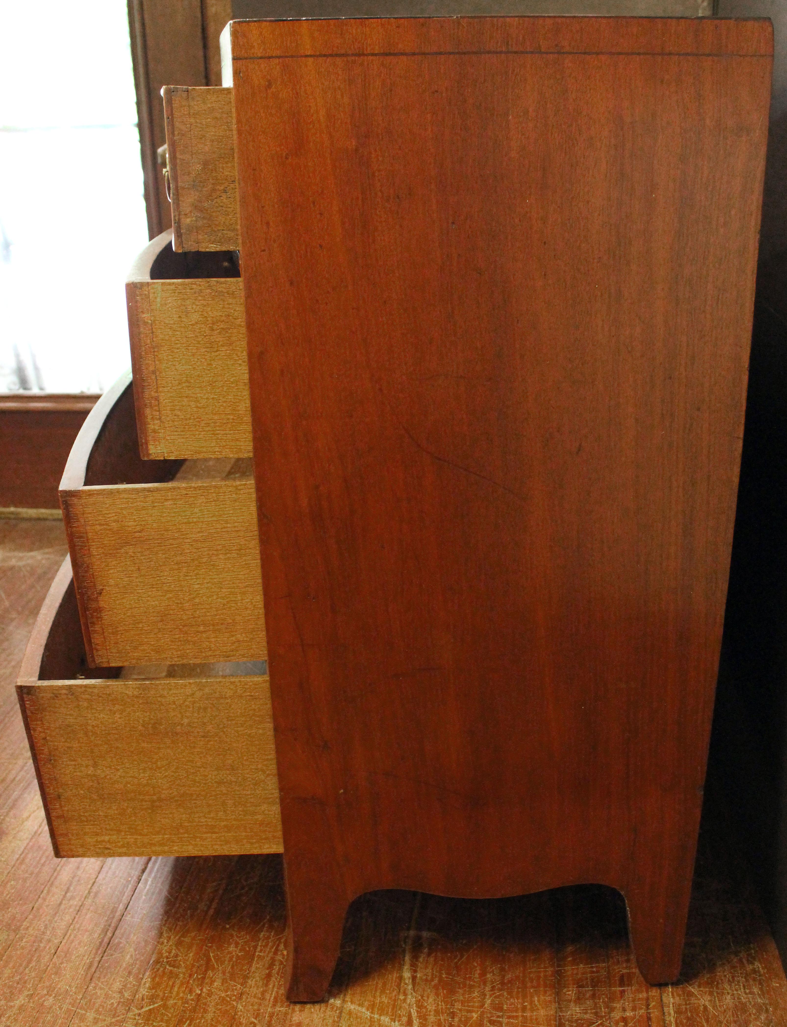 Cassettiera con fronte ad arco dell'inizio del XIX secolo, inglese. Periodo georgiano. Fronte ad arco, 2 cassetti corti e 3 lunghi graduati. Sollevato su piedini francesi a strombo. Grembiuli sagomati. Piano Caddy con incordatura in ebano lungo la