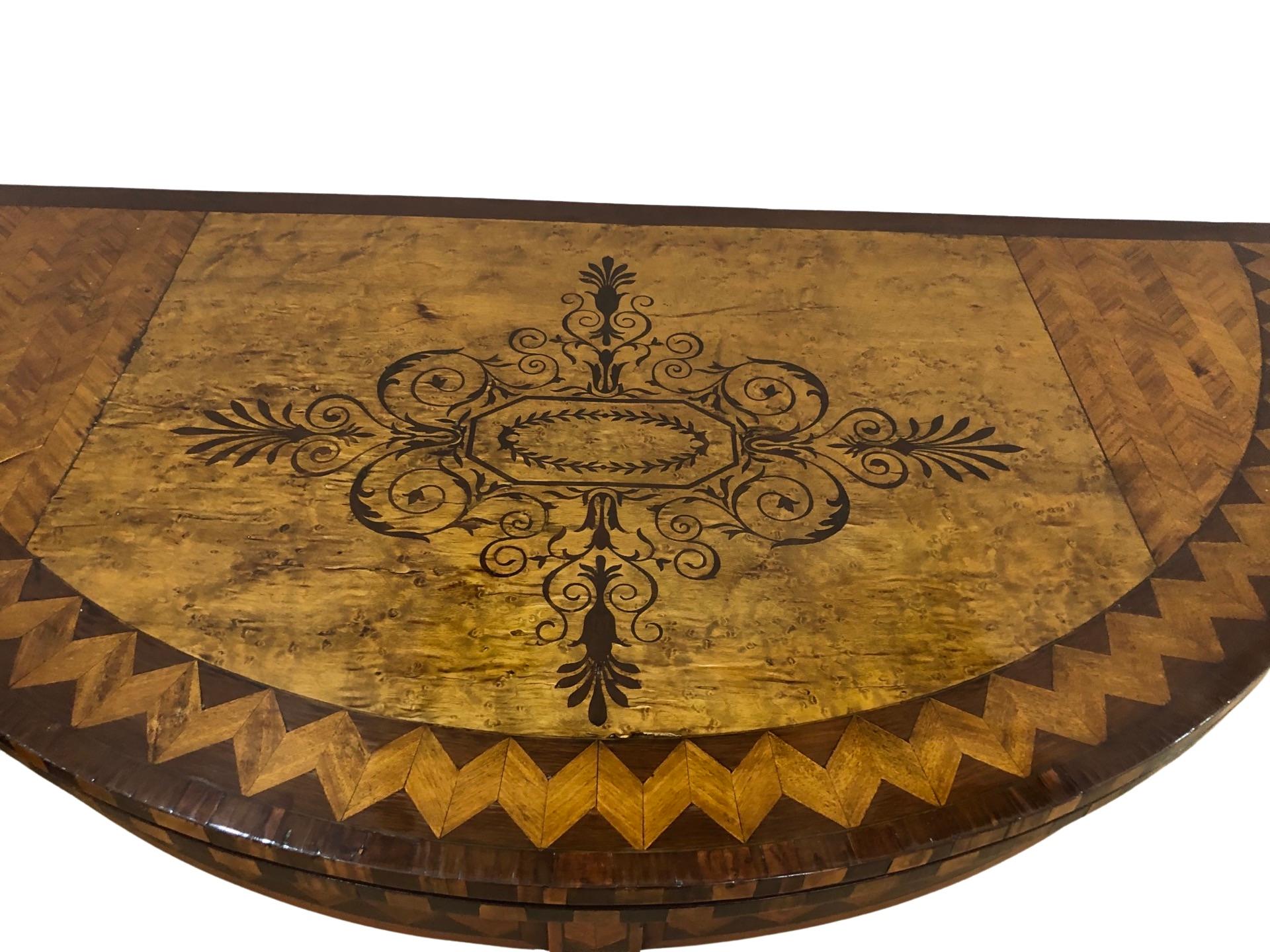 Late 18th century or more likely early 19th century English demi-lune card or game table with a beautiful inlaid top. The inlaid top features a birds eye maple with a mahogany inlaid design. Mahogany border flanks the herringbone design. Top opens