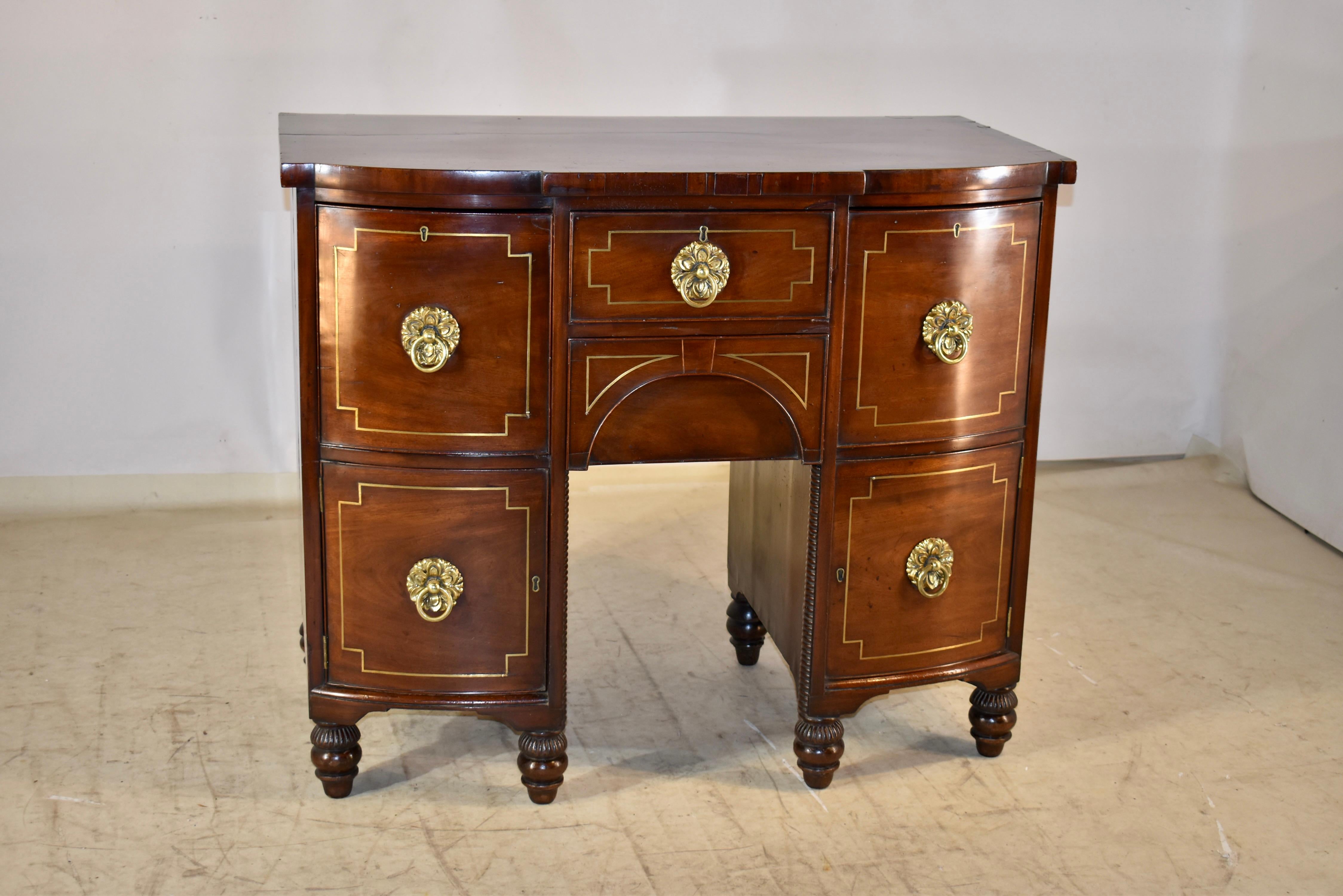 Early 19th century mahogany brand board, or small sideboard from England.  This piece has a banded mahogany edge with satinwood inlay around the top.  The top is shaped to compliment the curves of the piece below.  It has blocked out edges and a