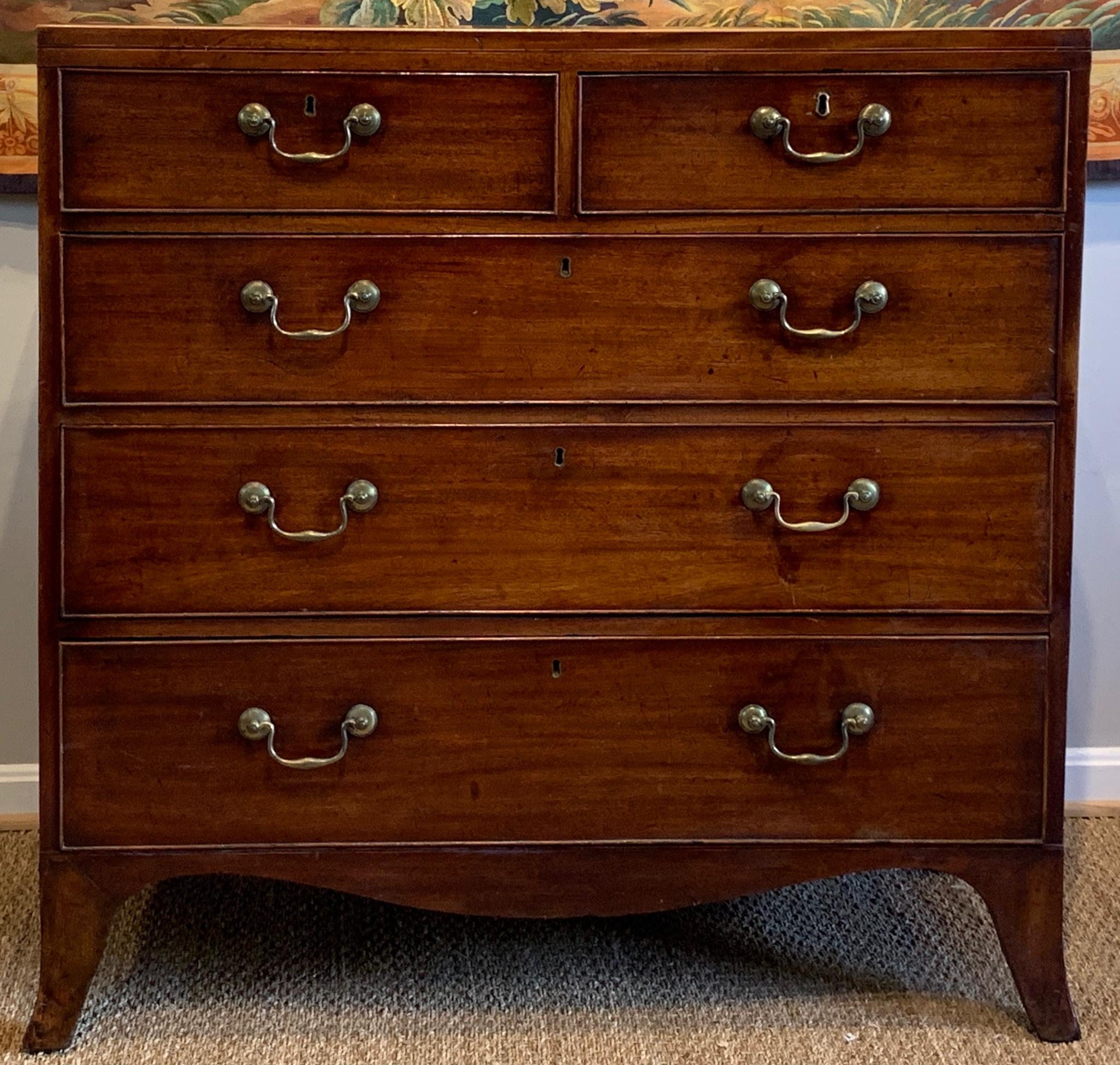 A simple and elegant George III mahogany 5-drawer chest comprising two short drawers over three graduated long drawers with original brass bale-handled pulls all resting on French splayed feet.