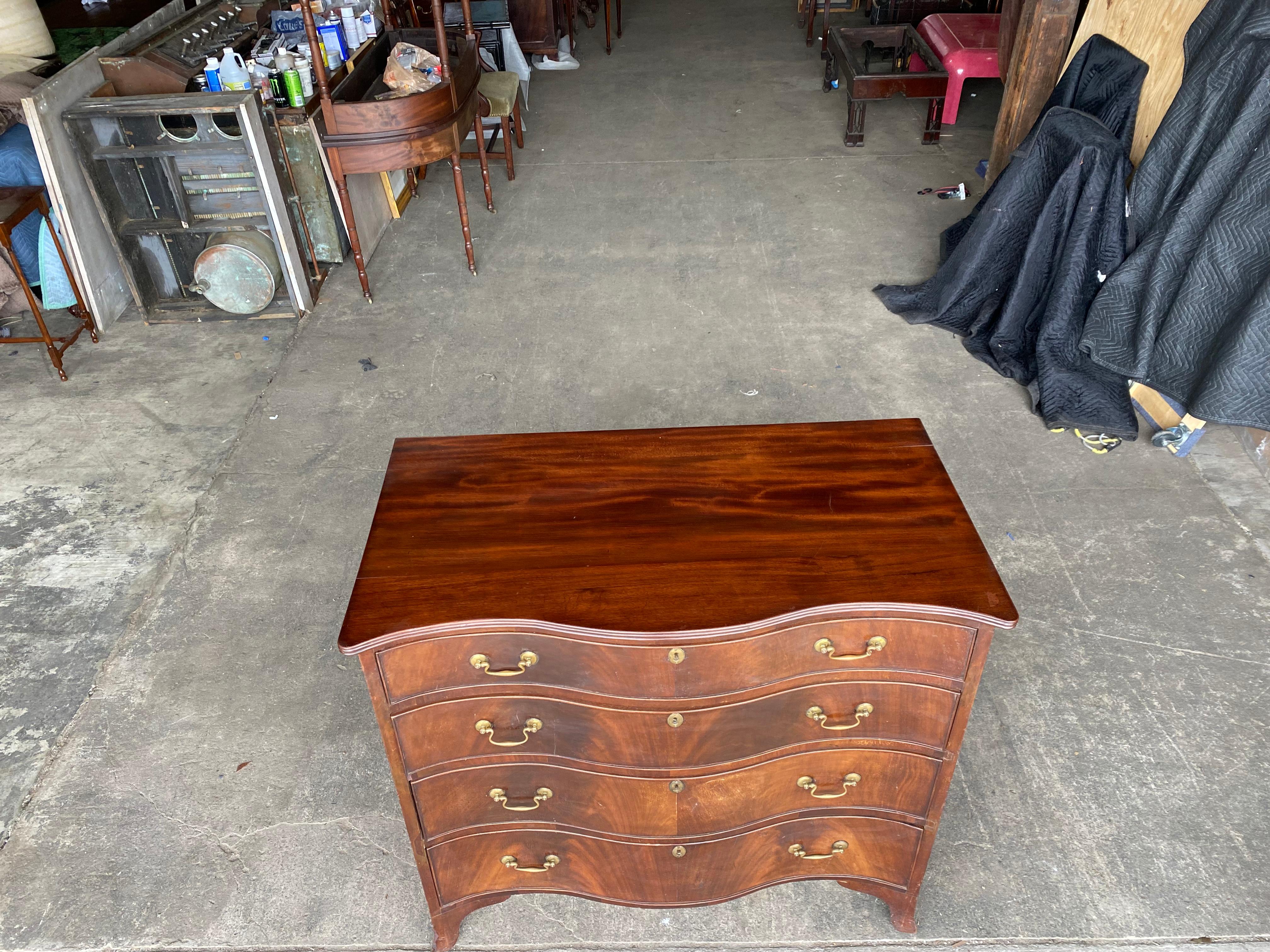 Early 19th century English mahogany serpentine chest on French feet. Wonderful grain, great scale.
