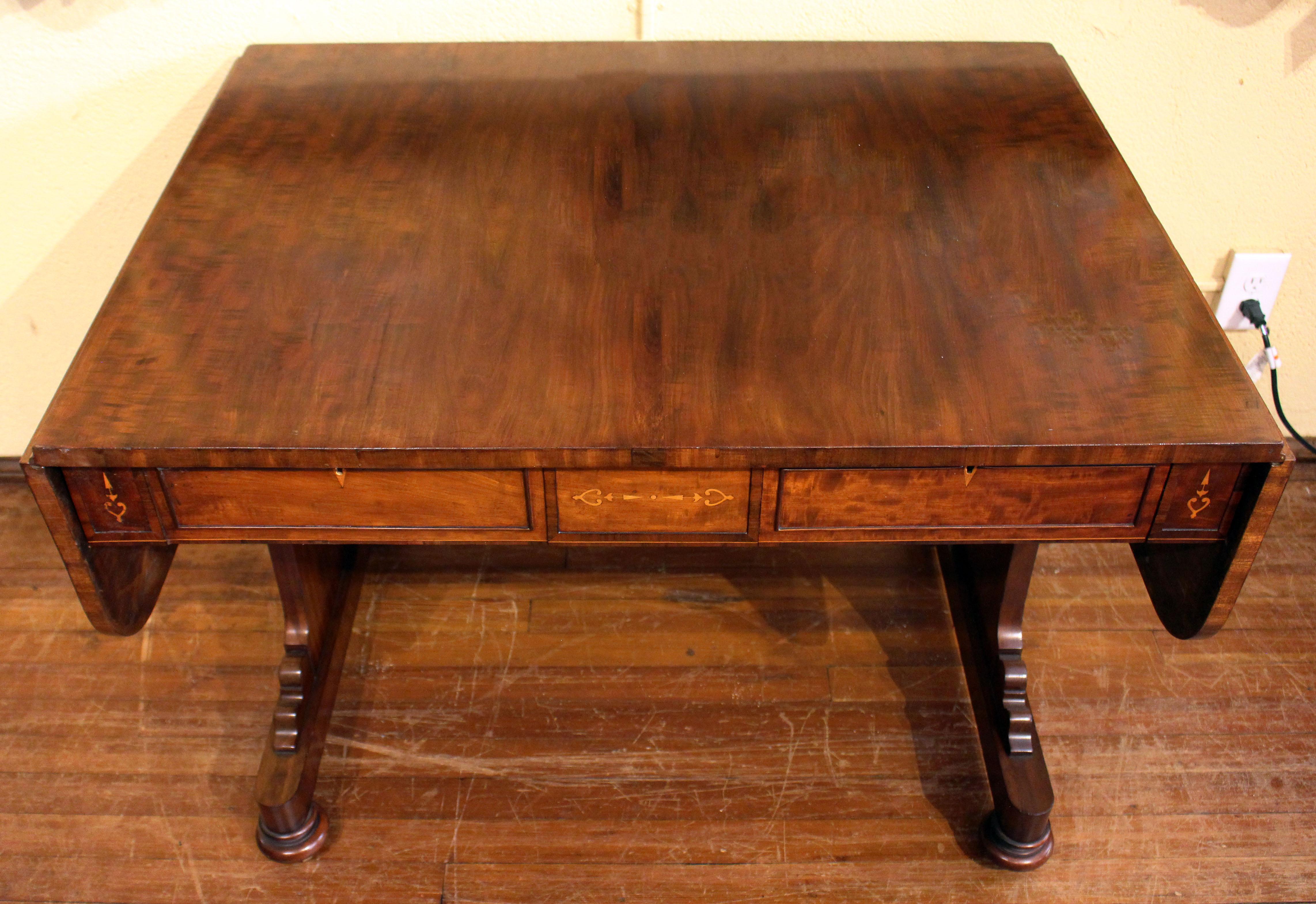 Circa 1820s sofa table in plum pudding mahogany with boxwood inlays and escutcheons. English, George IV. Opposing faux and functioning drawers. Sleek lines that blend with a multitude of styles. Oak and ash secondary wood. English. Measures: 30 3/8