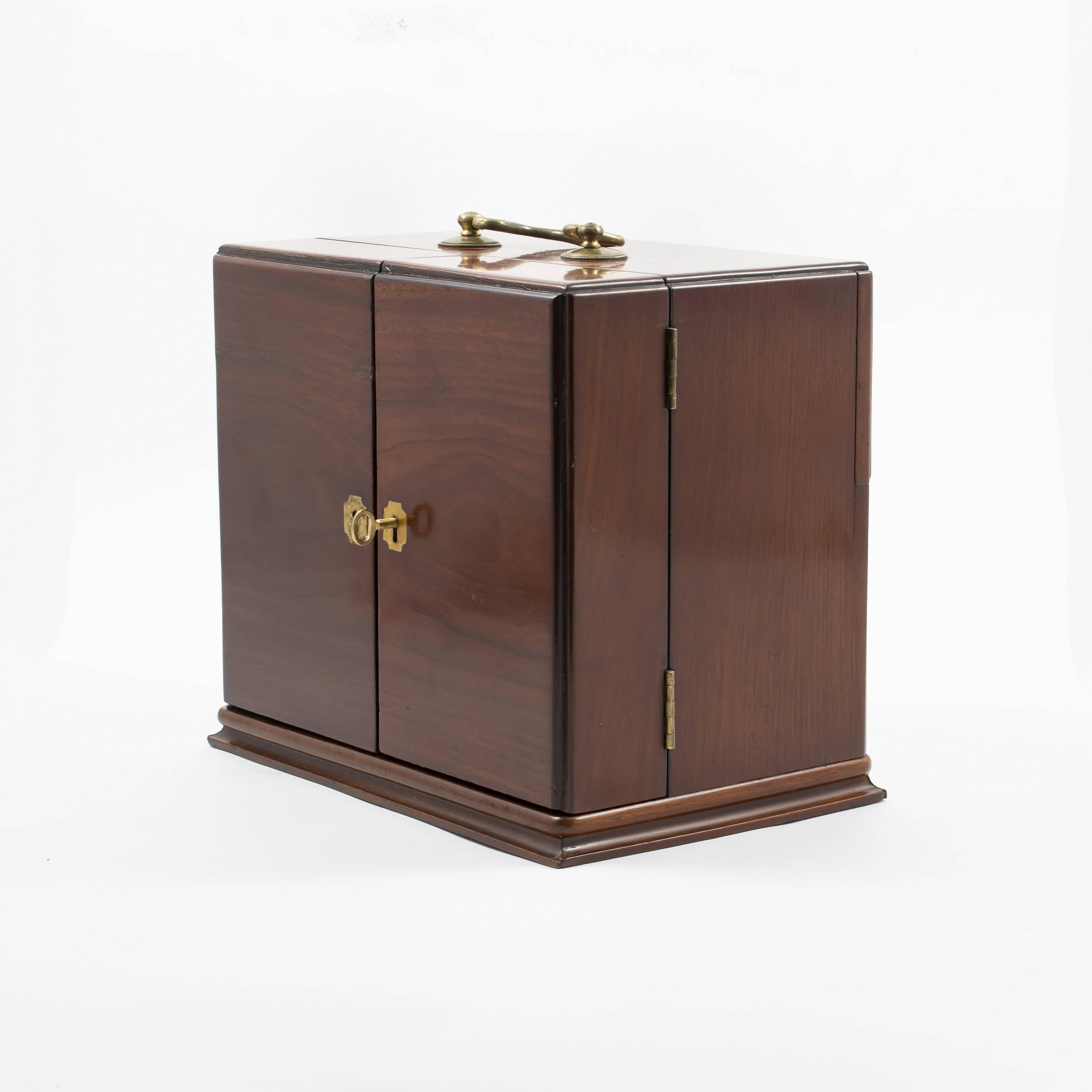 Early 19th century mahogany apothecary cabinet. Made from mahogany with original brass fittings.
The doors open to reveal compartments for bottles and drawers.
A secret sliding compartment at the rear of the box.
The box comes with a couple of