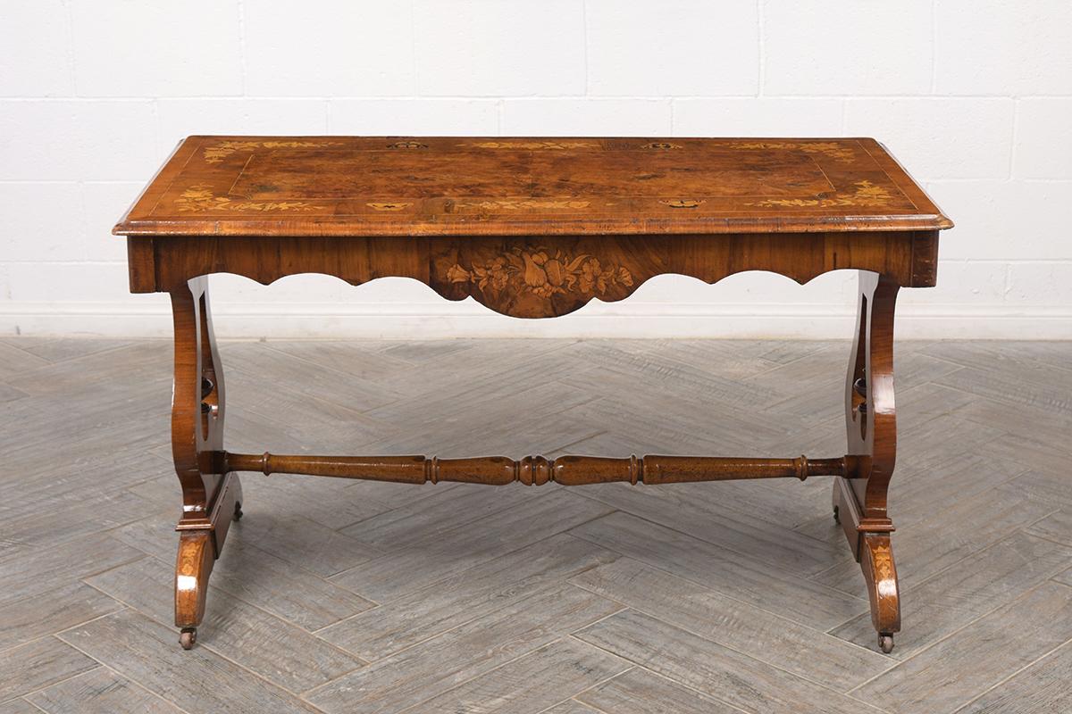 This 1840s English-style Writing table has been professionally restored, is made out of walnut wood with its original natural color and newly varnished finish. The center table features a beautiful handcrafted burled top with intricate marquetry