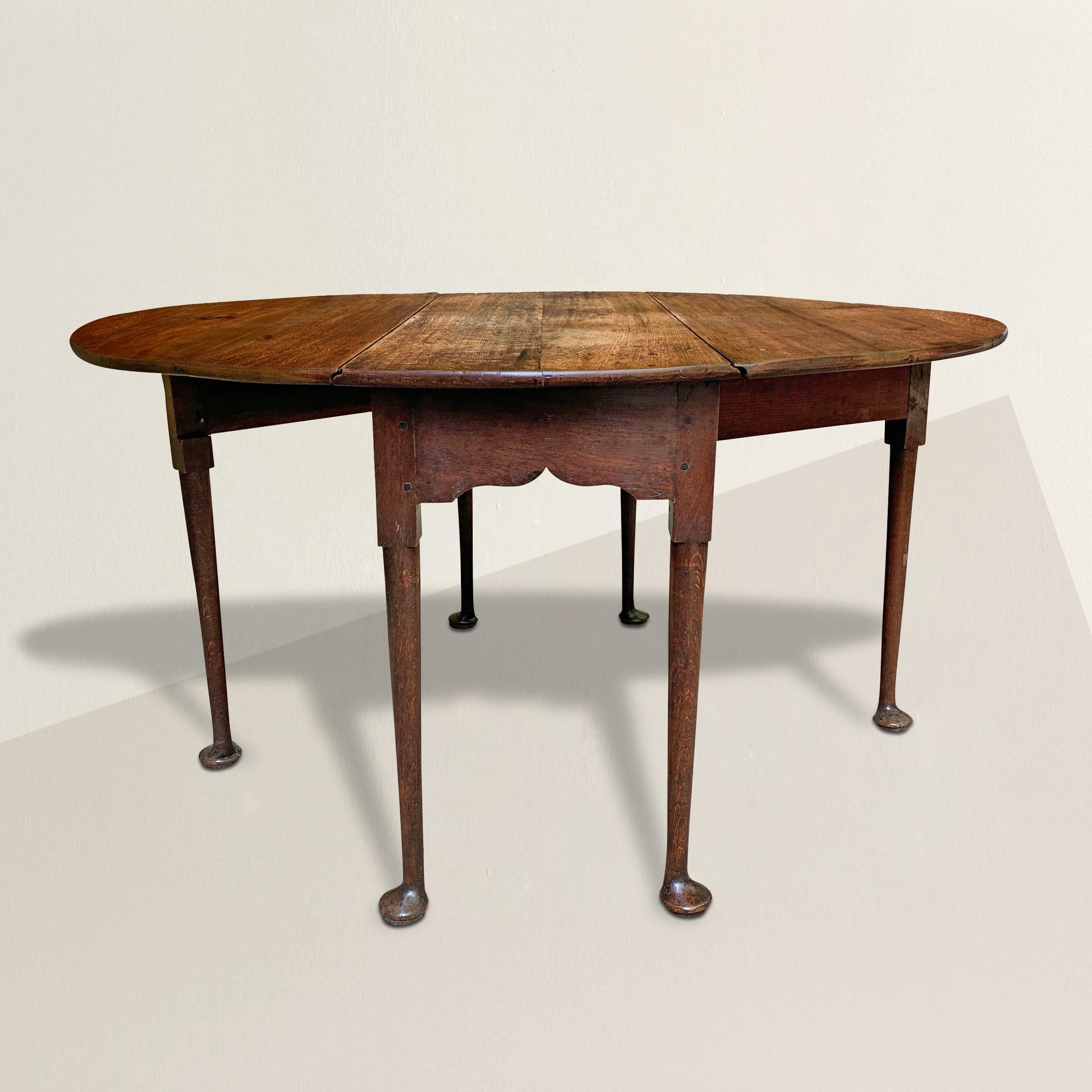 A fantastic early 19th century English Queen Anne oak drop-leaf gate-leg breakfast table with round straight tapered legs ending in the most wonderful large pad feet that give the appearance as though the table could get up and walk away. This table