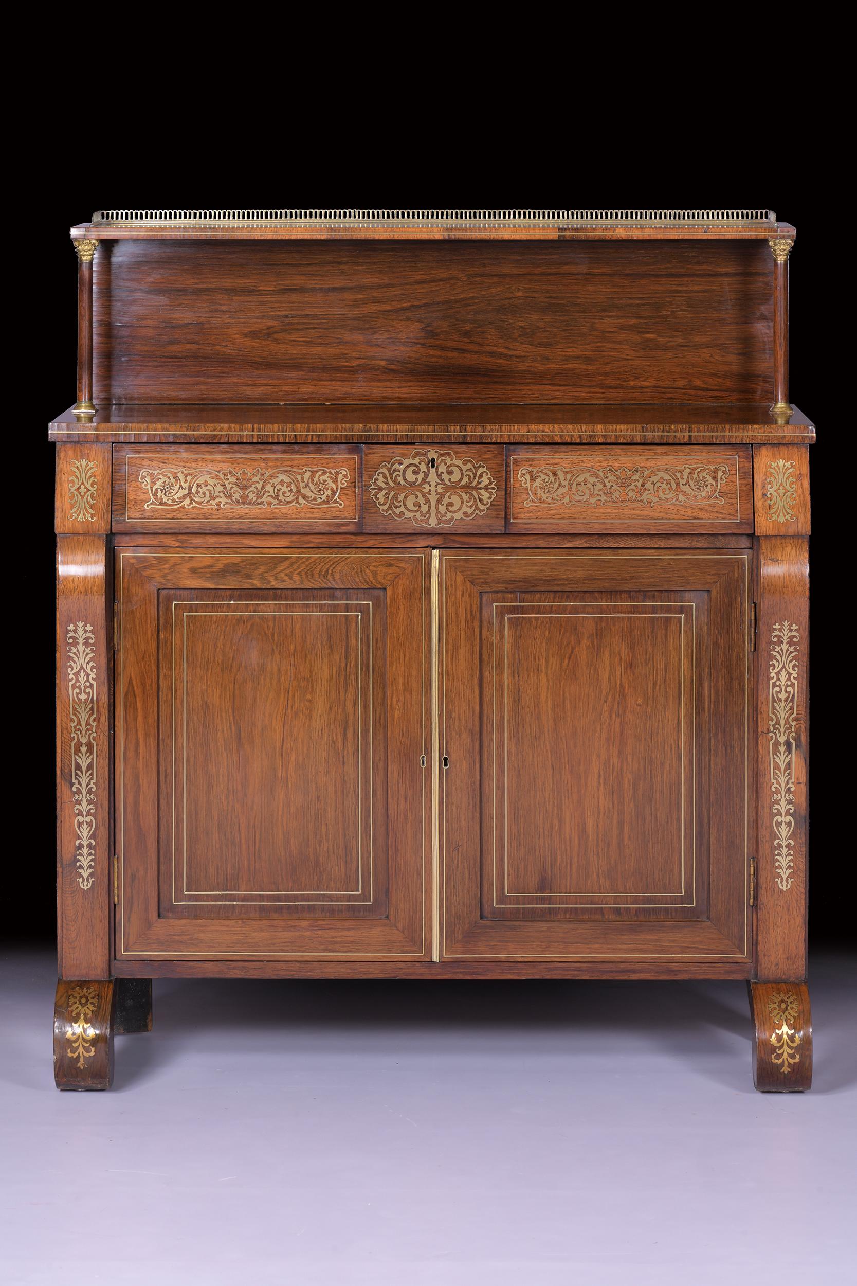 The superstructure with a rectangular three quarter gallery shelf on a pair of turned Corinthian pillars. Profusely inlaid with engraved brass scrolling foliate and floral marquetry the rectangular top over a secretaire drawer enclosing four