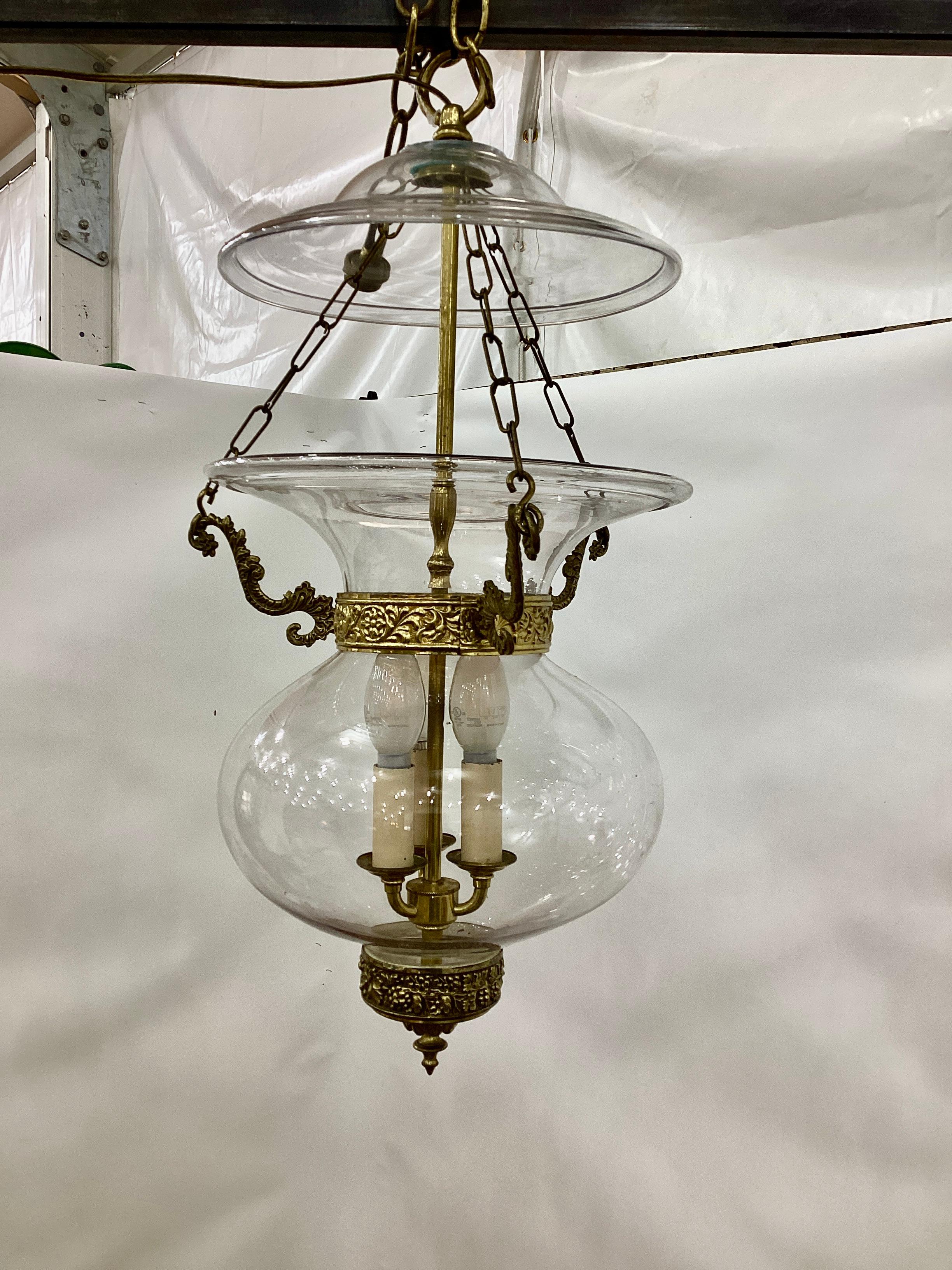An early 19th century English Regency clear glass bell jar lantern with brass collar circa 1830. The lantern is fitted with a three chain drop and a smoke bell. Lantern is wired and in working condition.