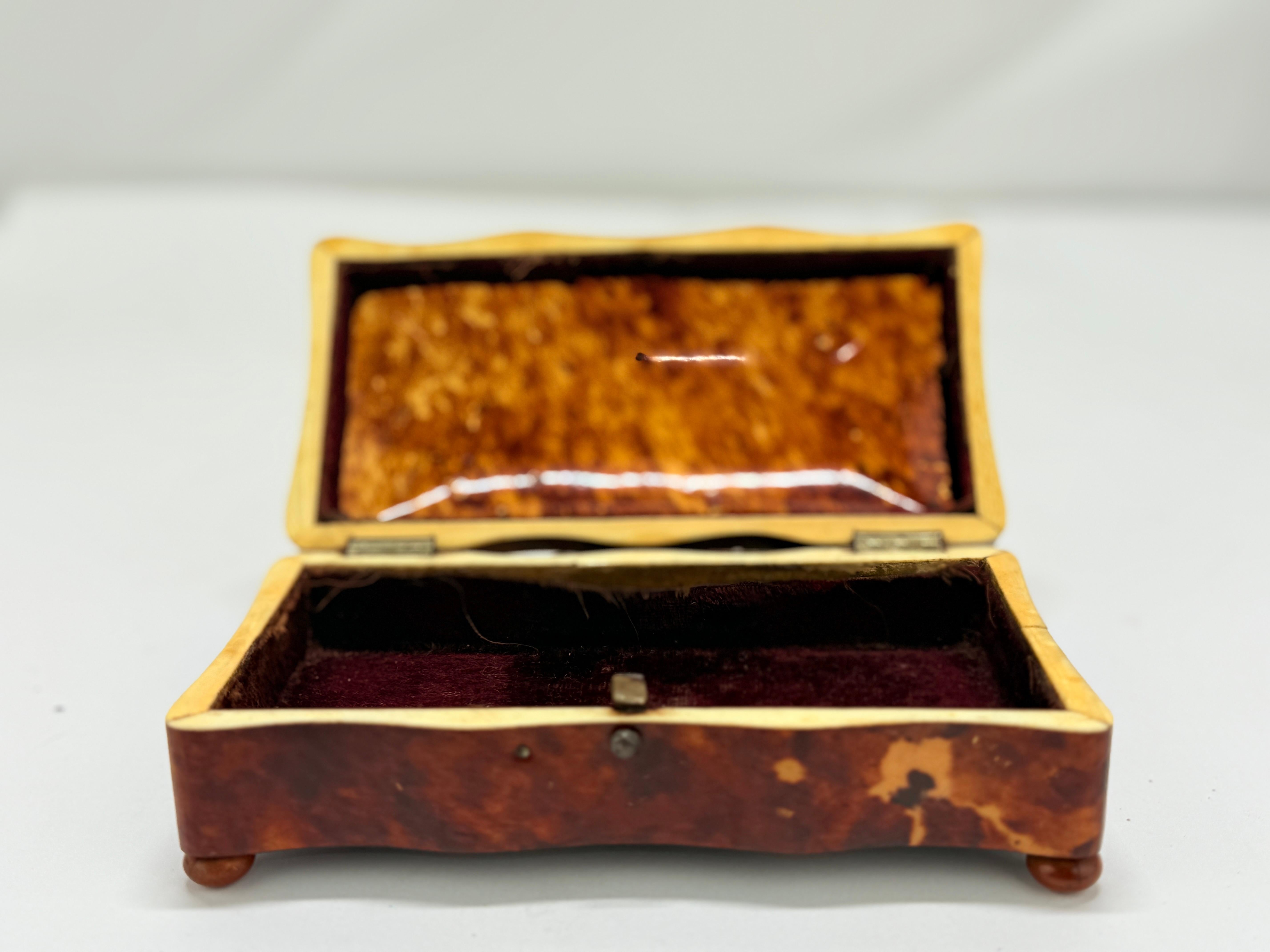 Raffinata scatola inglese dei primi anni del XIX secolo, costruita in epoca Regency in finta tartaruga riccamente figurata, con corde e accessori color avorio, ed elevata su piedini a bussola compressi. L'esemplare più grande, un porta tè con