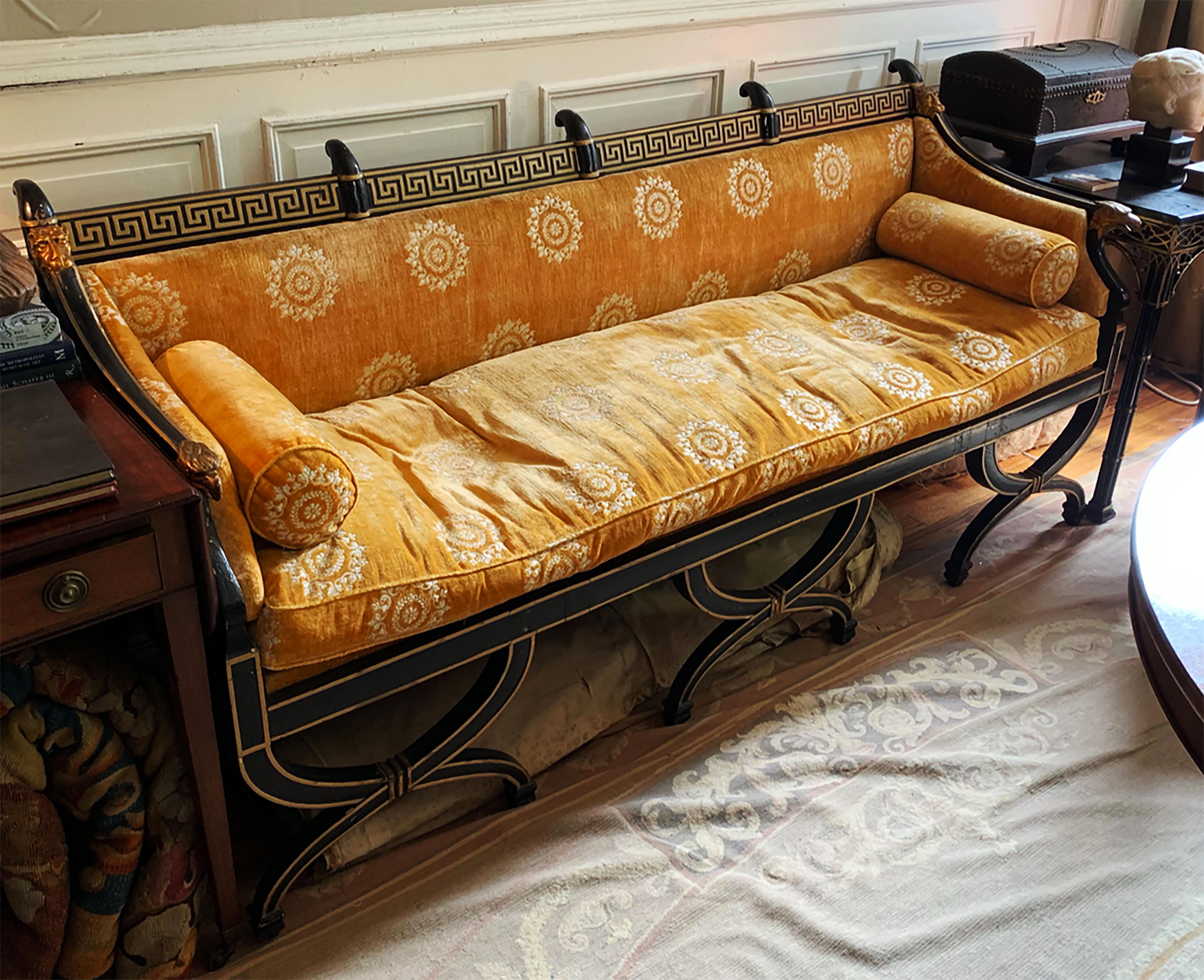 An outstanding Regency sofa in neoclassical taste. The couch is supported by Curule form legs with gilt edges. The arms of the piece exhibit eagle armrests and lion masks. The headrail is decorated with a bold Greek key meander. The whole is