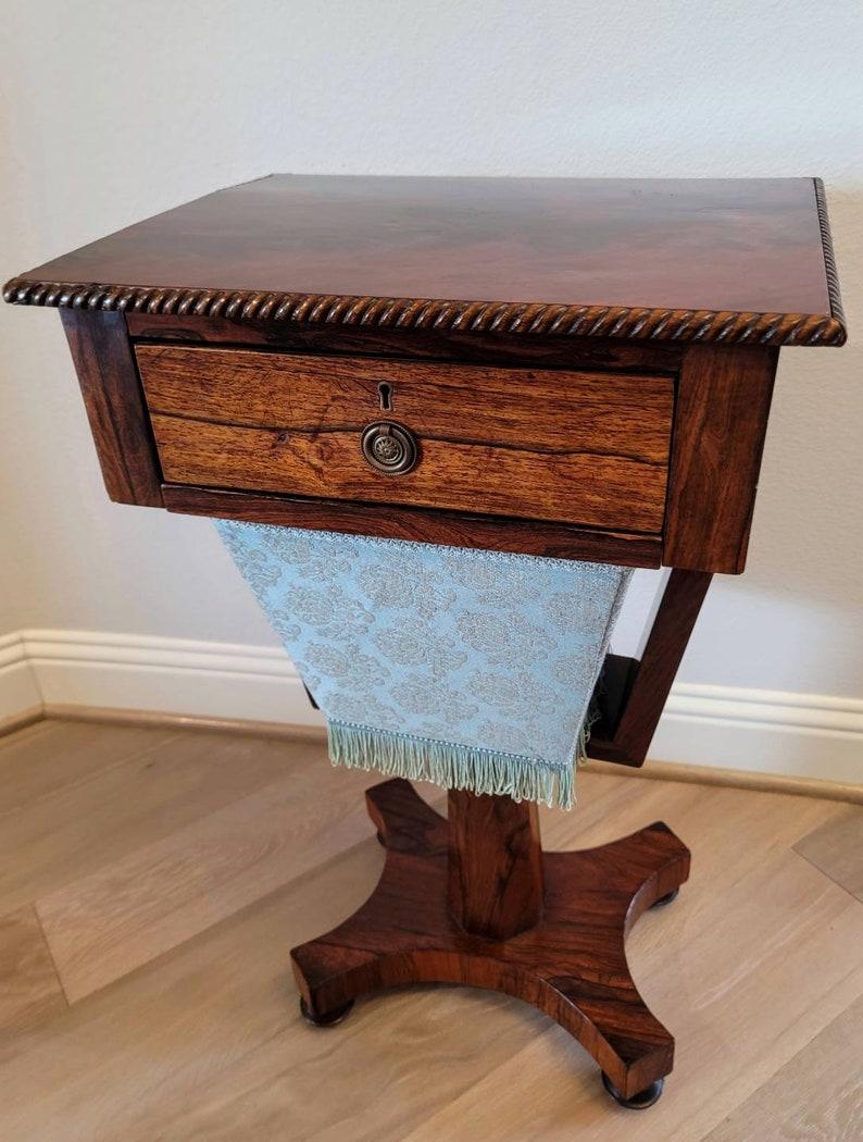 An elegant Regency period English mahogany and rosewood work table, circa 1815, in the manner of Gillows, having an attractive flame mahogany top with rope trim detail, above a single drawer with quality hand-cut dovetail joinery, over a removable