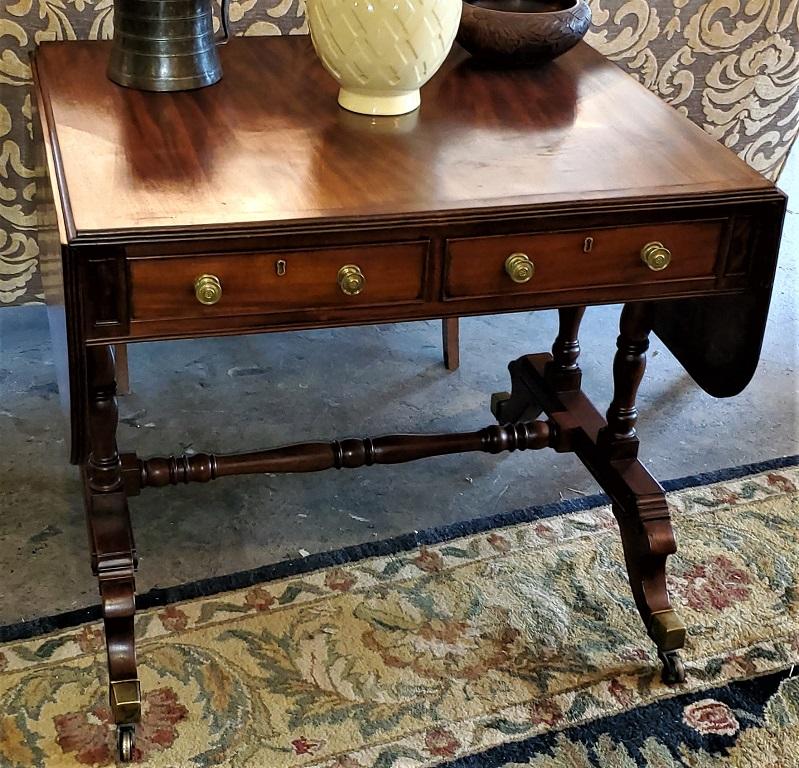 Presenting a stunning early 19th century English Regency sofa table.

Made from flamed mahogany, circa 1810-20.

Drop leaves on either side which extend when raised and supported by pull out hinged brackets.

Beautiful Regency reeding to the