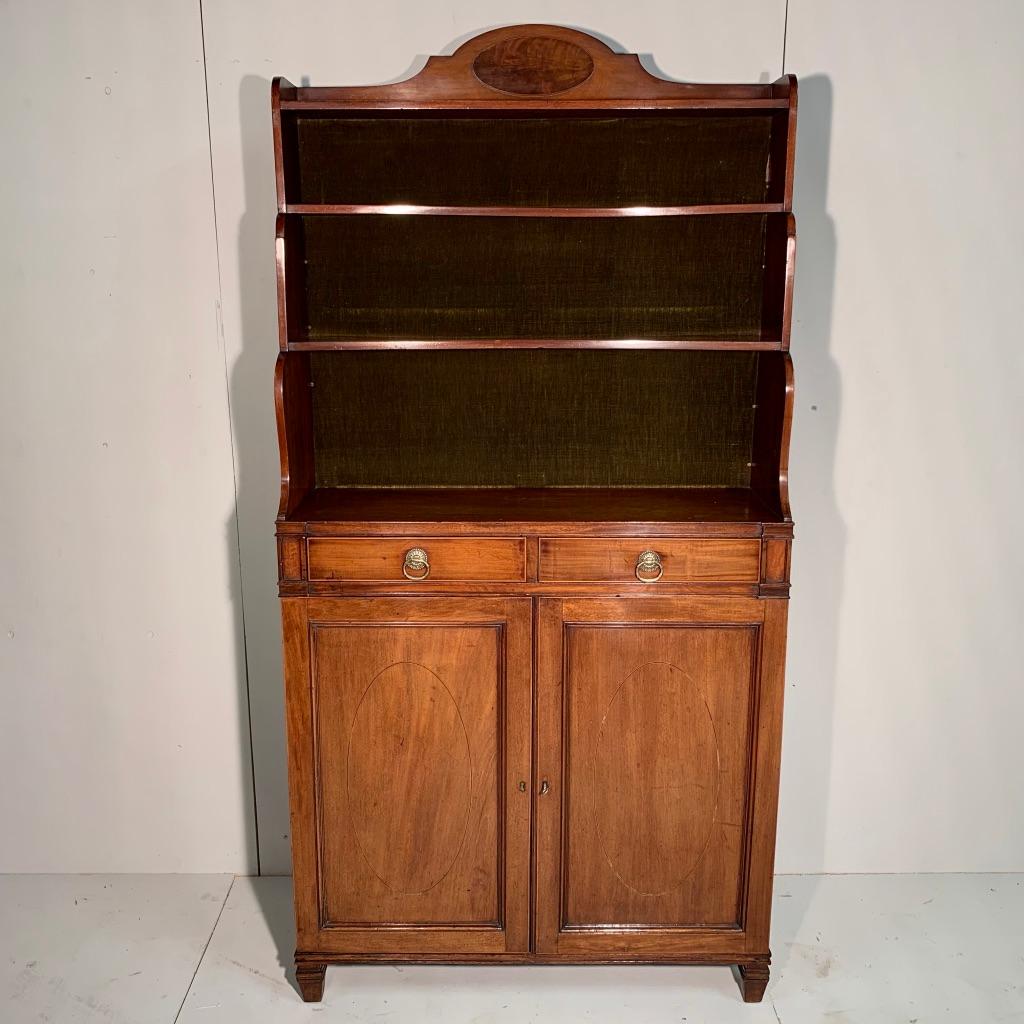 Unusual Regency period waterfall bookcase in mahogany, circa 1820.
The open waterfall bookcase gives generous space for books or display with the four surfaces.
The cabinet base has two drawers and below there are the two doors which open up to