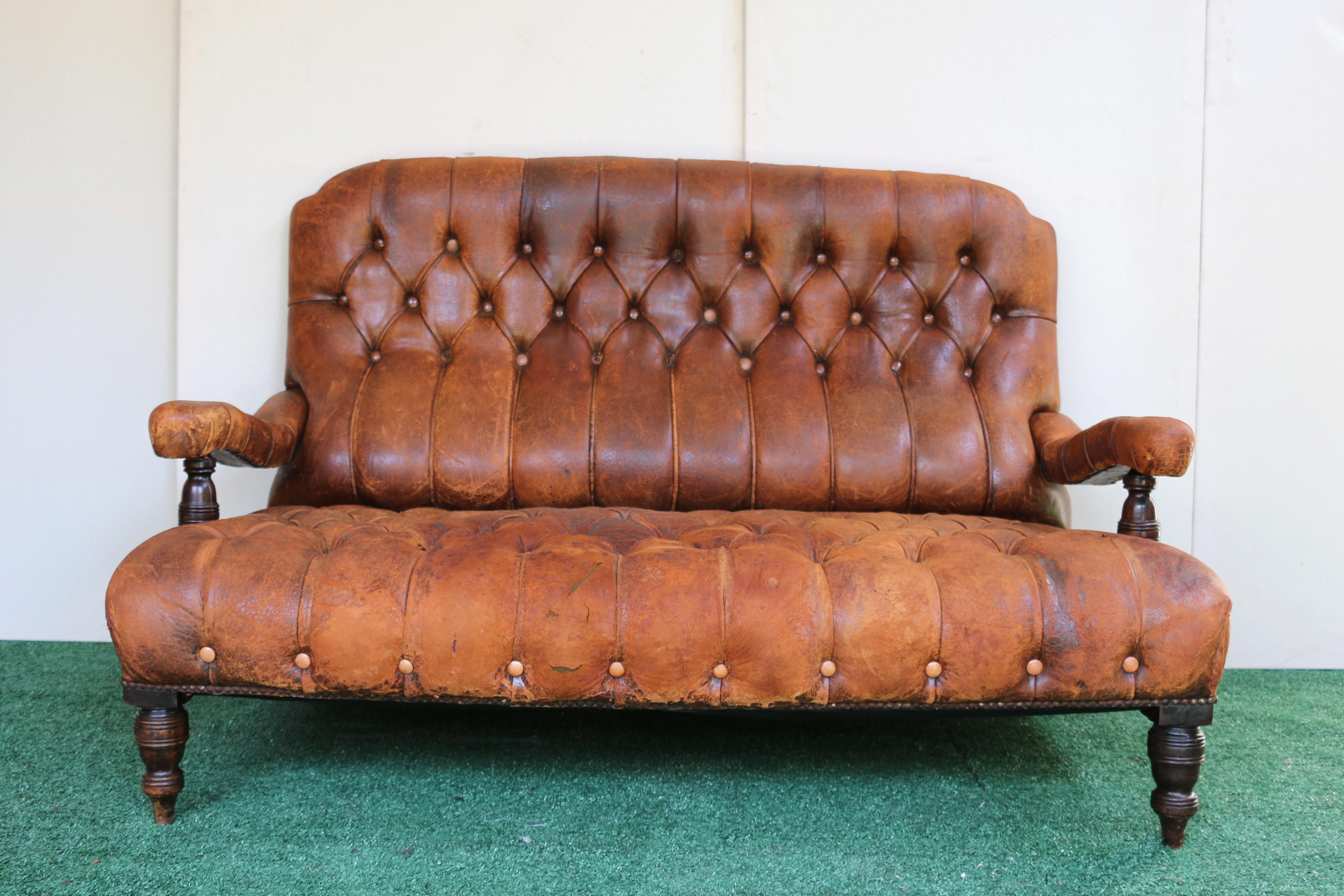 Superbe canapé touffeté en cuir marron vieilli. Le design du canapé suggère un style classique qui peut s'adapter à différentes tendances de décoration.