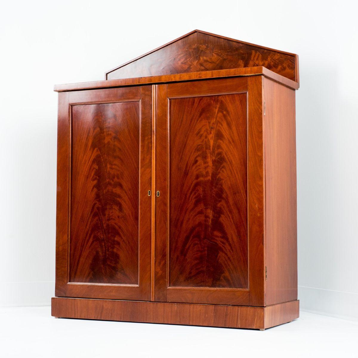 William IV two door server on base molding and mounted with a pedimented back splash in mahogany and book matched mahogany veneers.
England, circa 1820.