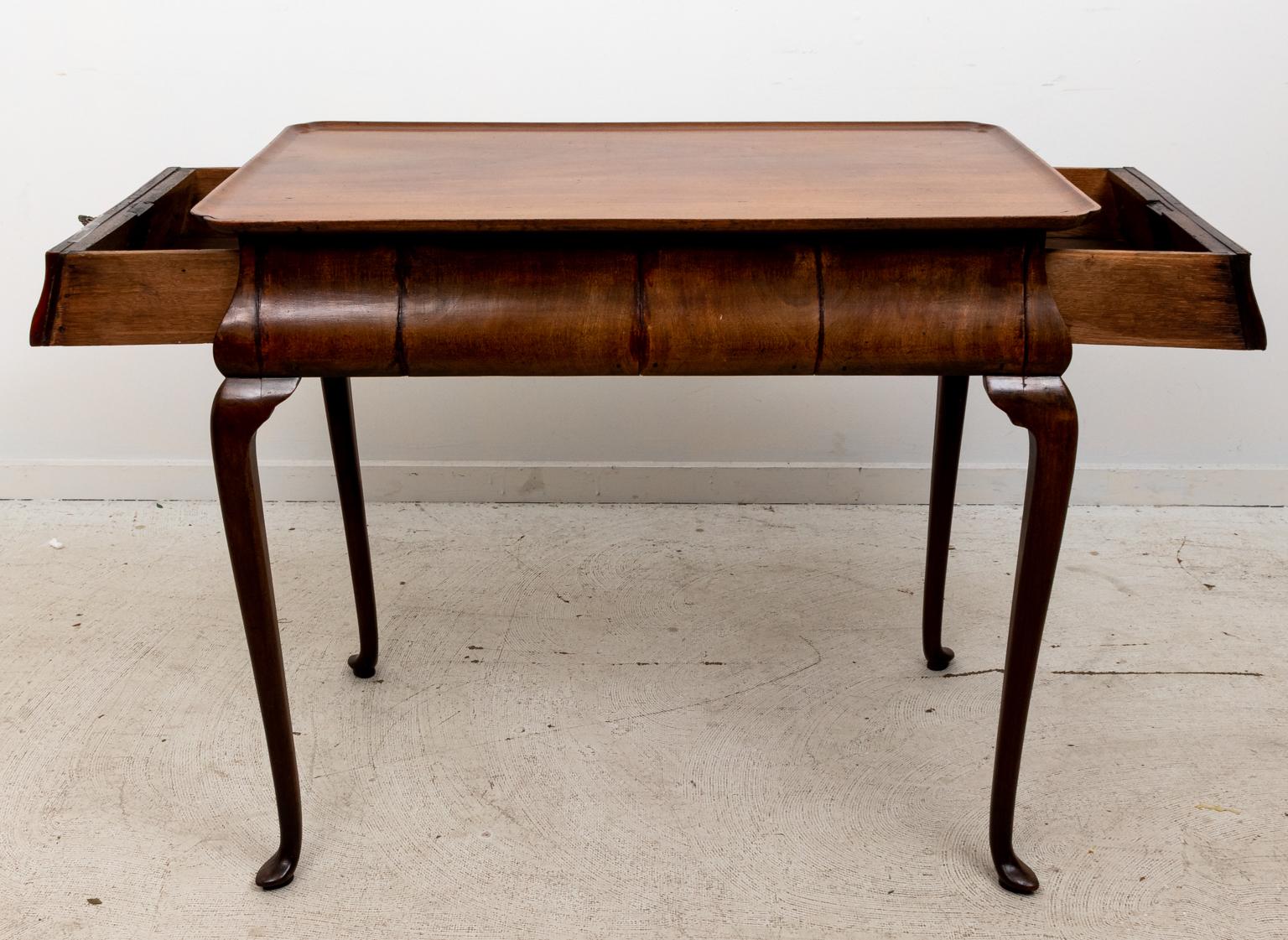 Circa early 19th century English Walnut tea table with hidden drawers and bat's wing escutcheon. The piece also features cabriole legs with pad feet. Please note of wear consistent with age.