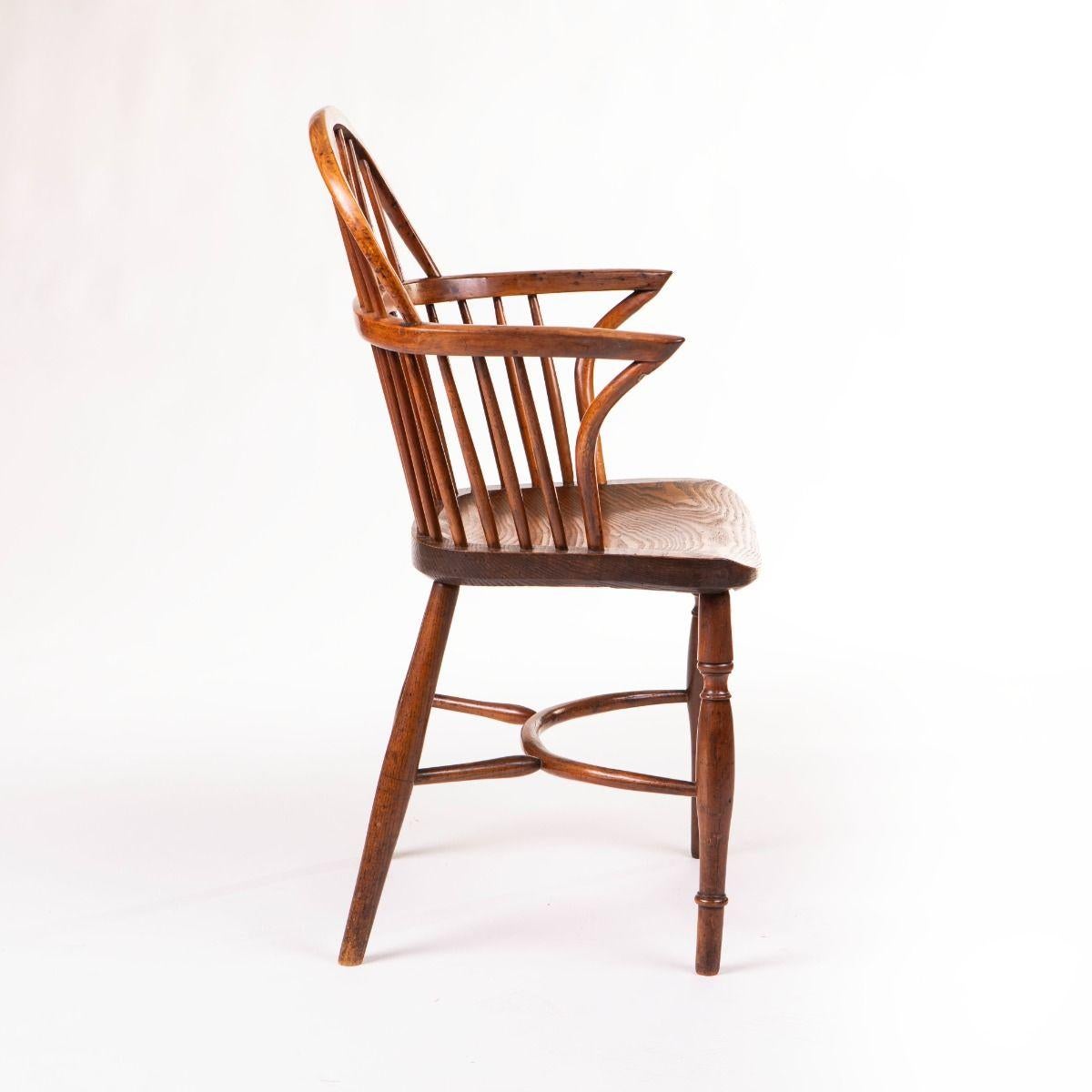 Früher Windsor-Sessel mit einer anmutig geschwungenen Rückenlehne mit dekorativen Spindeln, einem durchbrochenen Mittelstück und elegant geformten Armlehnen - alles aus Eibe, einem reich gemaserten Holz, das häufig für frühe Windsor-Stühle verwendet