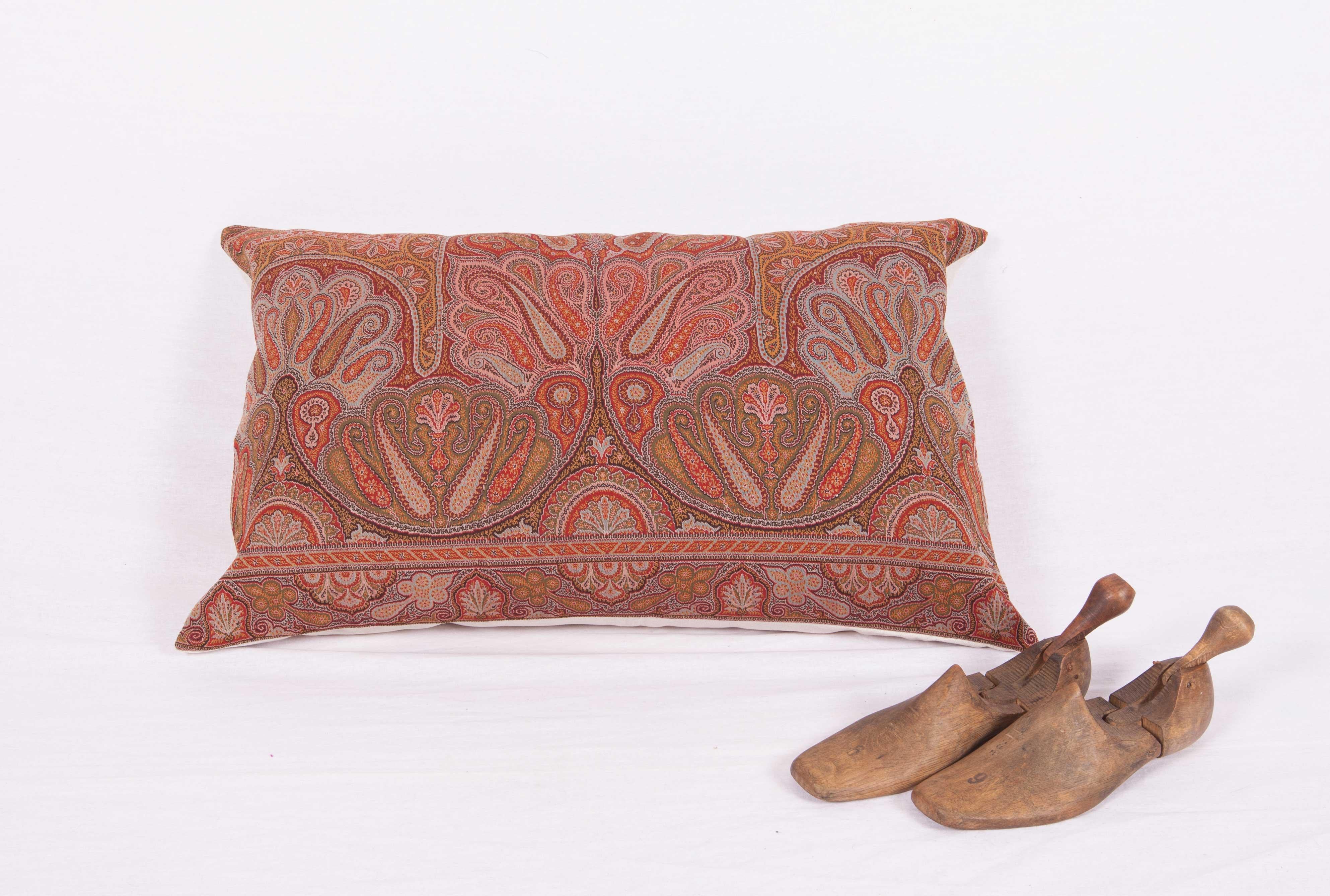 The pillow is made out of an early 19th century paisley shawl. It does not come with an insert but it comes with a bag made to the size and out of cotton to accommodate the filling. The backing is made of linen. Please Note: Filling is not provided.
