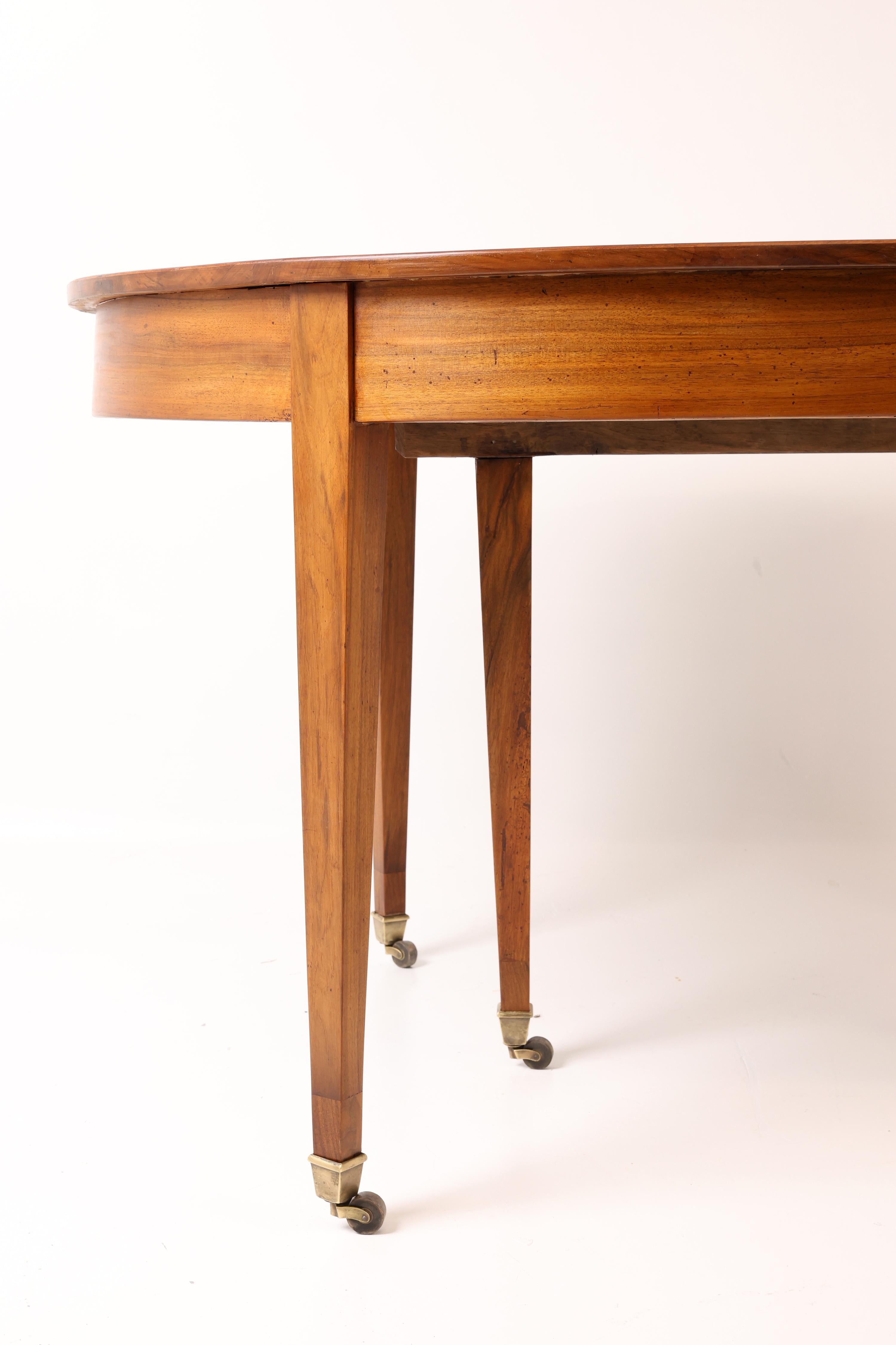 Francese Tavolo da pranzo allungabile in noce dell'inizio del XIX secolo con rotelle in ottone in vendita