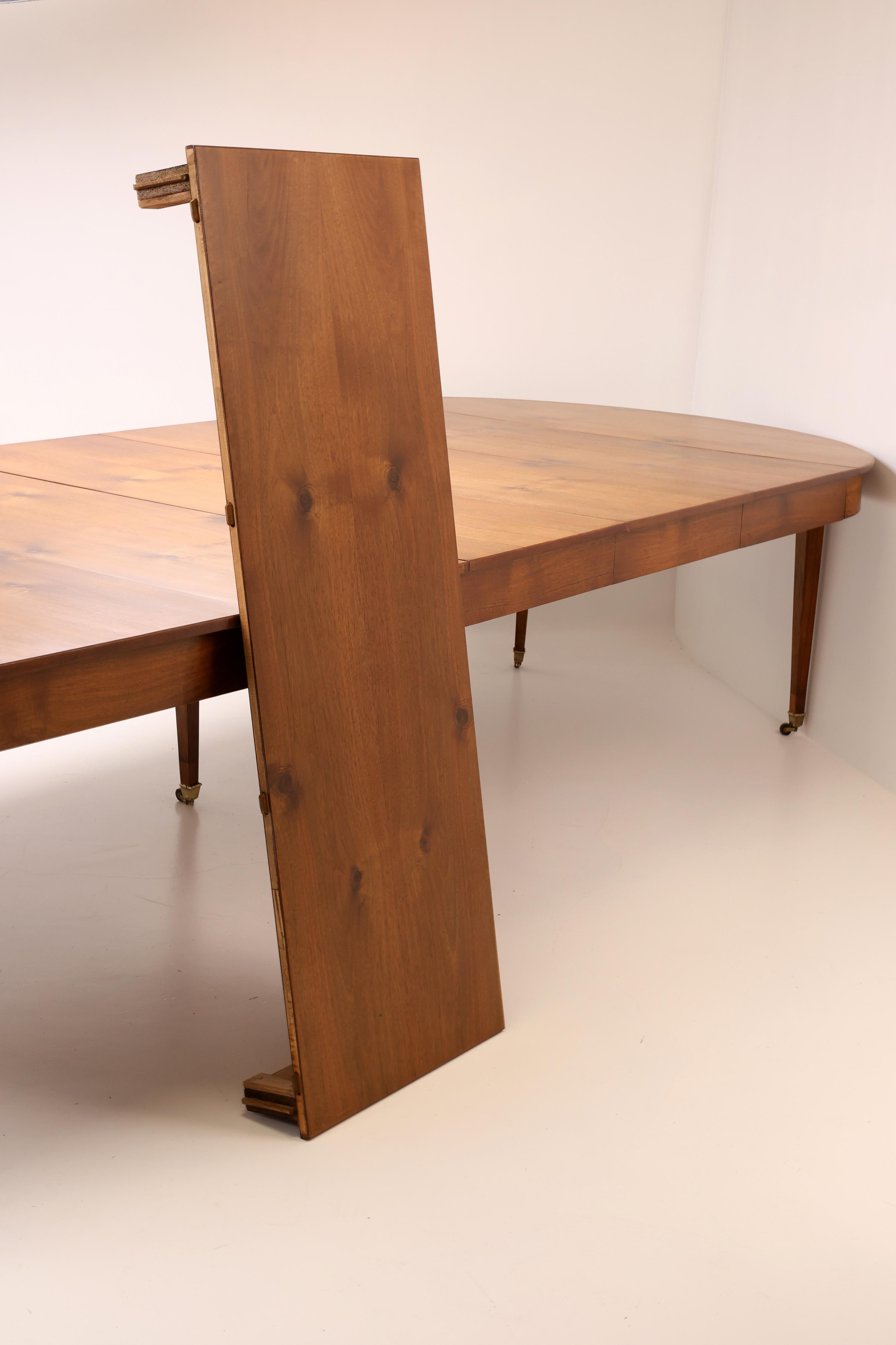 A olio Tavolo da pranzo allungabile in noce dell'inizio del XIX secolo con rotelle in ottone in vendita