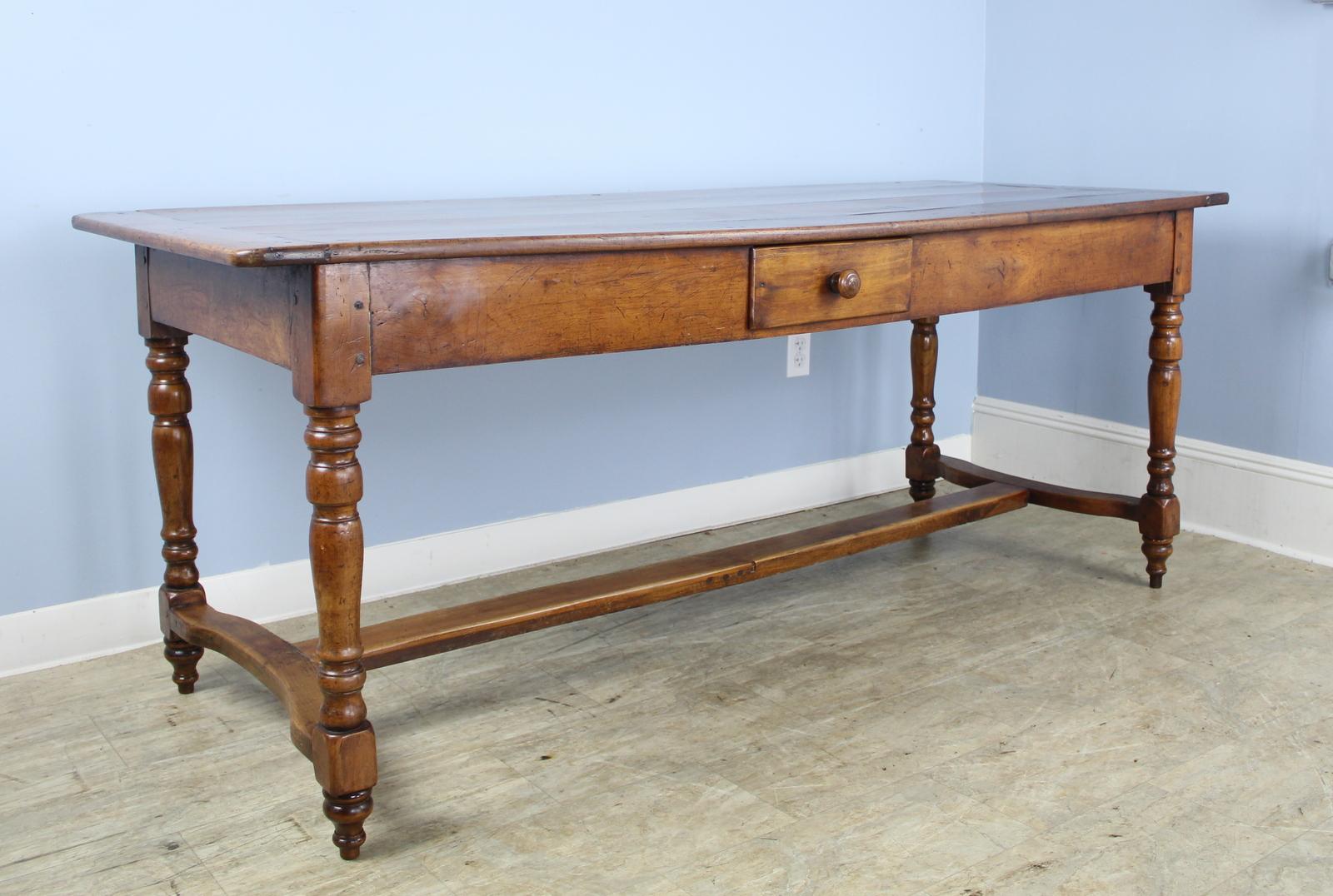 A stunning early dining table with chunky turned legs and a trestle base, all done in mellow fruitwood. The patina and grain on this piece are exceptional. It's bold look would make this wonderful in a country home, or as a library table in a more