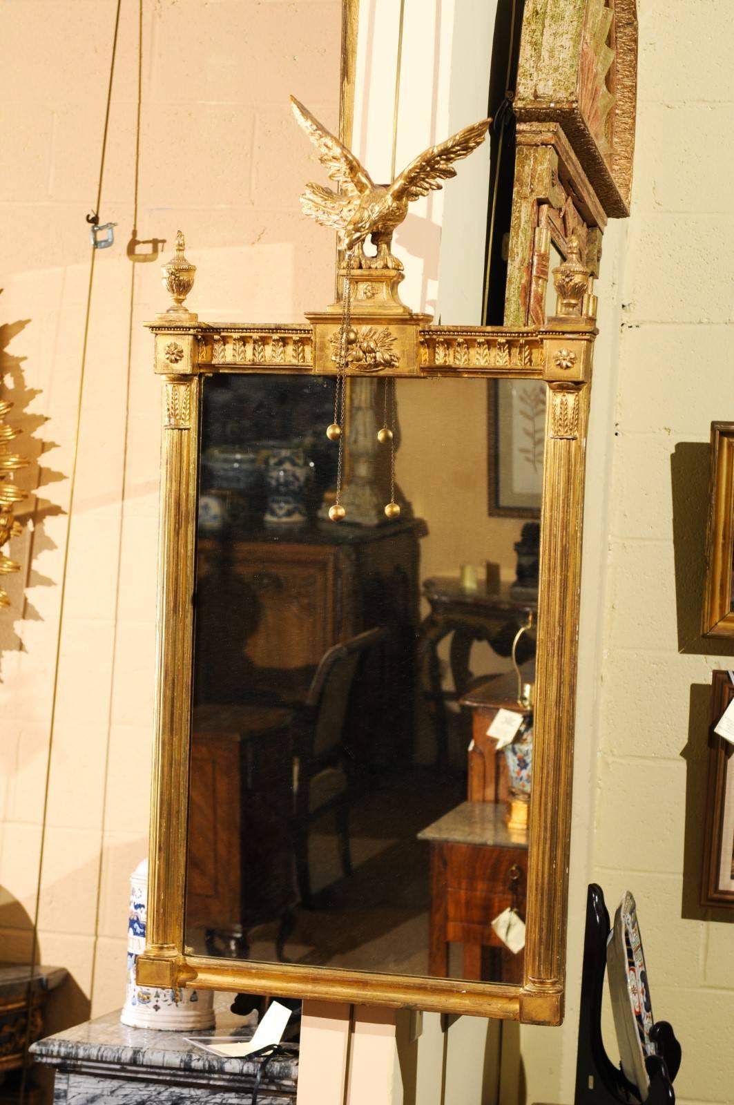 The federal giltwood mirror with eagle crest in neoclassical motifs.