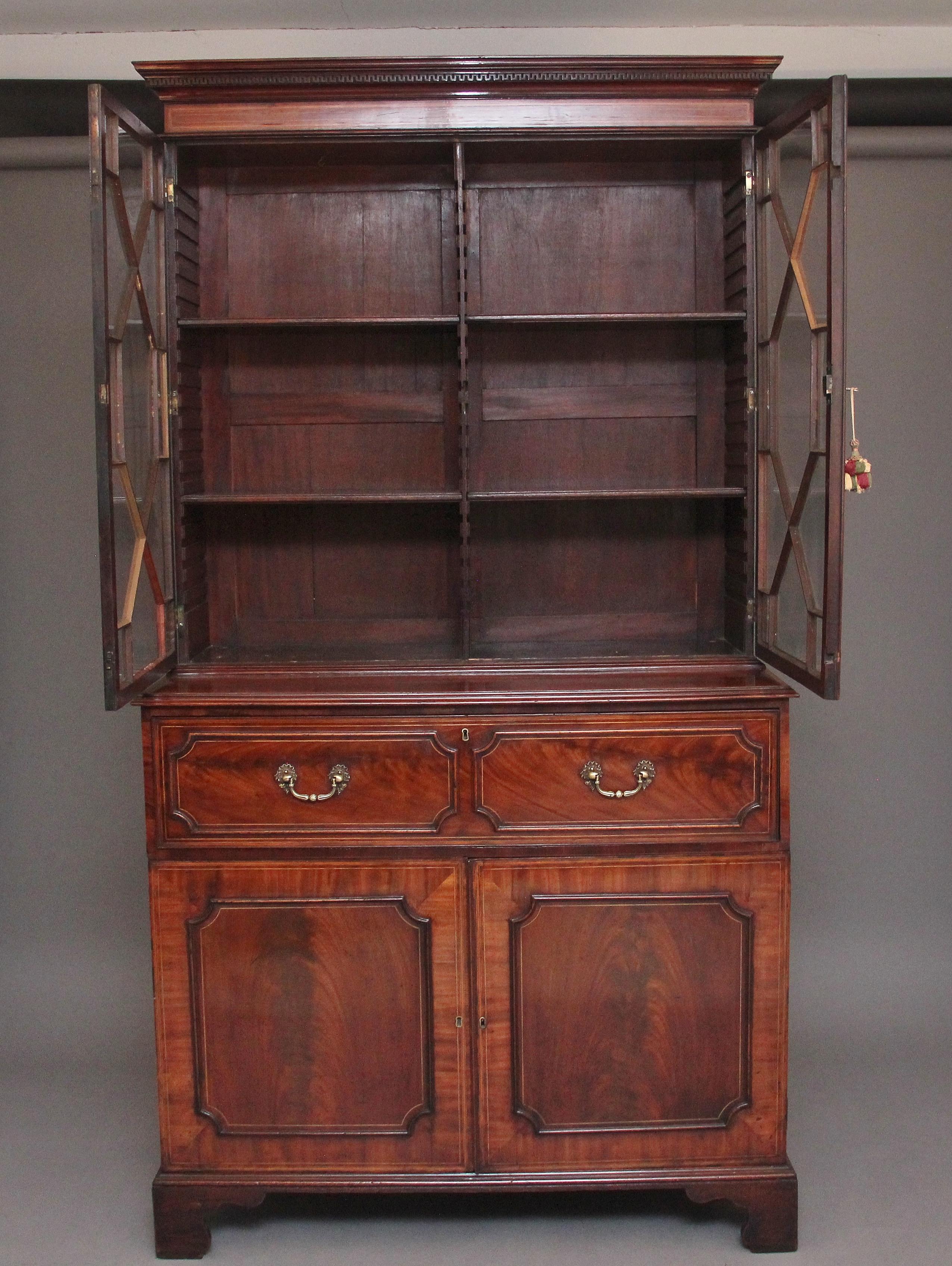 Early 19th century flame mahogany secretaire bookcase with a nice moulded cornice with dentil moulding, the bookcase having two astrigal glazed doors opening to reveal four adjustable shelves inside, the bottom section having a pull out secretaire