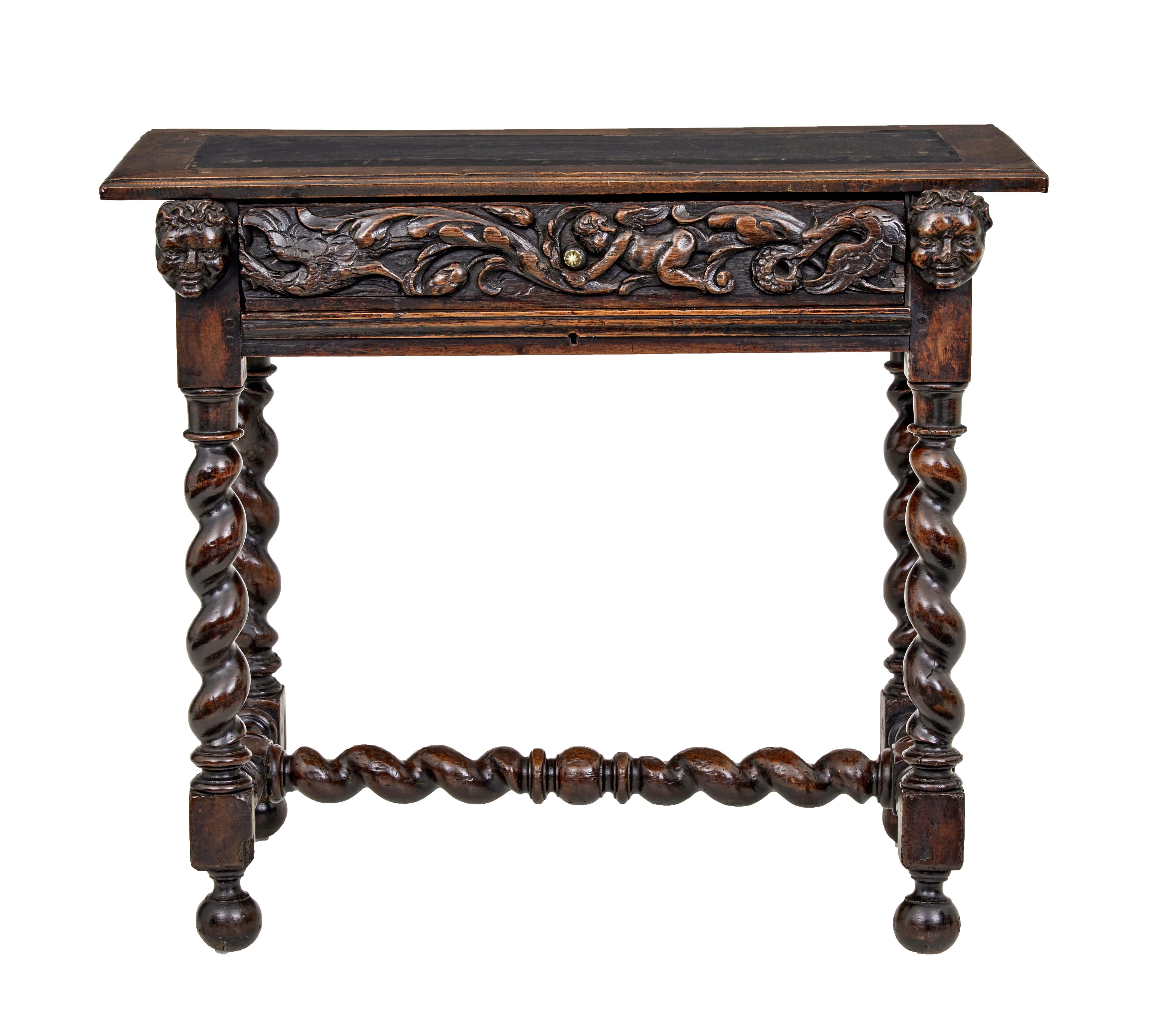Early 19th century Flemish carved walnut side table circa 1820.

Character walnut single drawer side table.  Top with inset leather panel and walnut border.  Below a profusely carved drawer with later brass handle, flanked either side by