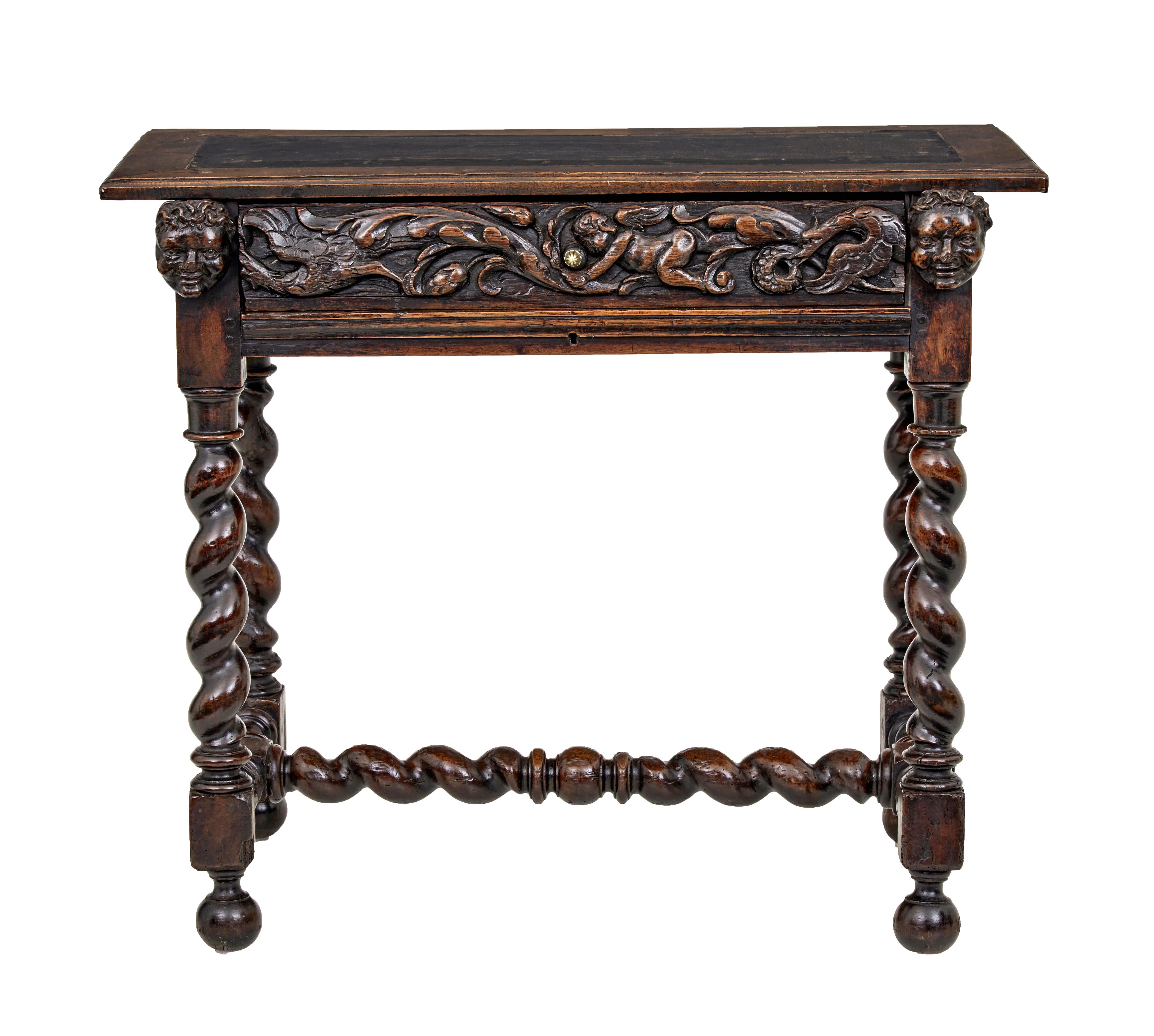 Early 19th century Flemish carved walnut side table circa 1820.

Character walnut single drawer side table. Top with inset leather panel and walnut border. Below a profusely carved drawer with later brass handle, flanked either side by