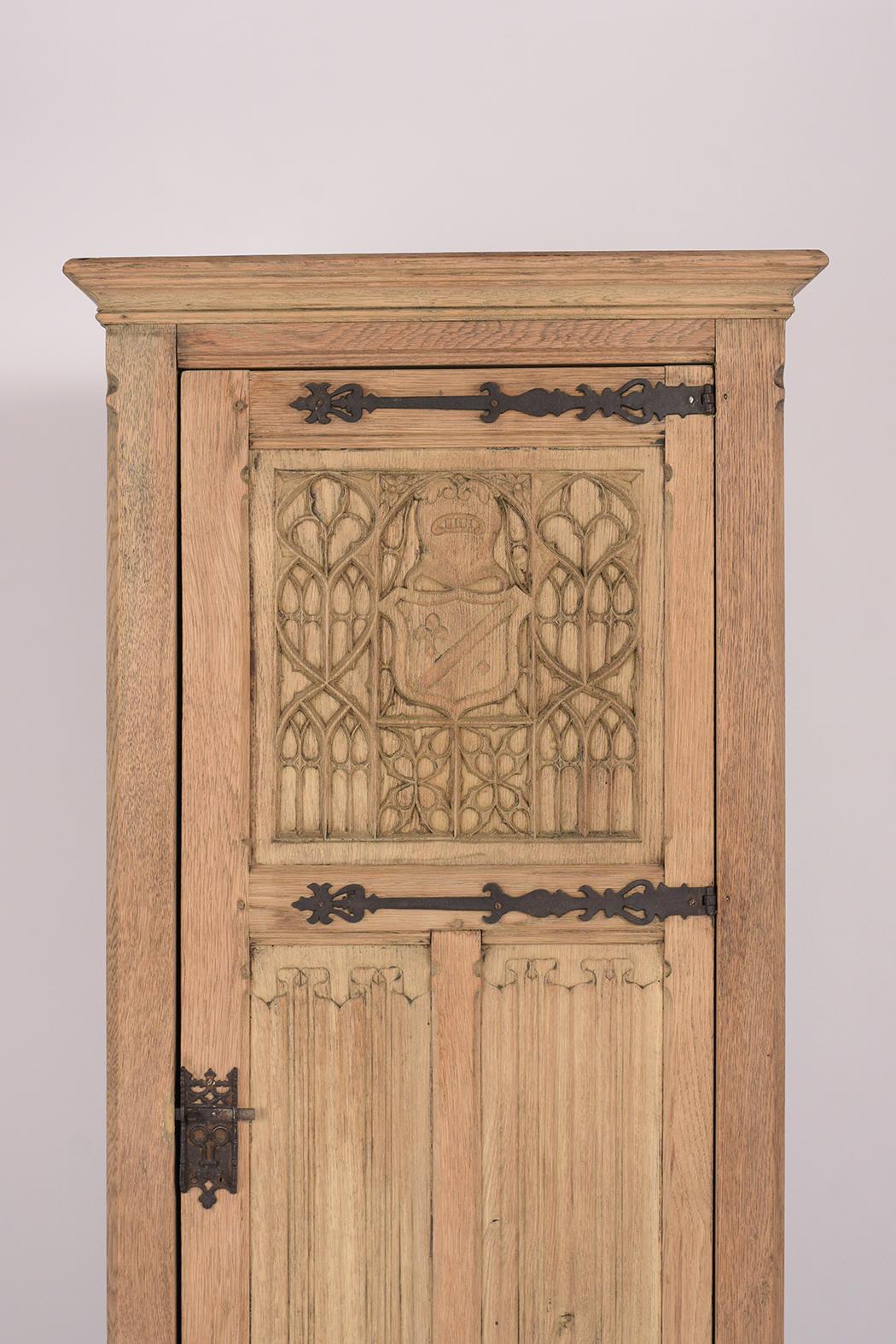 This Remarkable French 19th century armoire is in good condition, made out of solid oakwood, and features a newly bleached wood finish. The piece comes with a single door with hand carved panels, the top panel has an elegantly carved shield design,