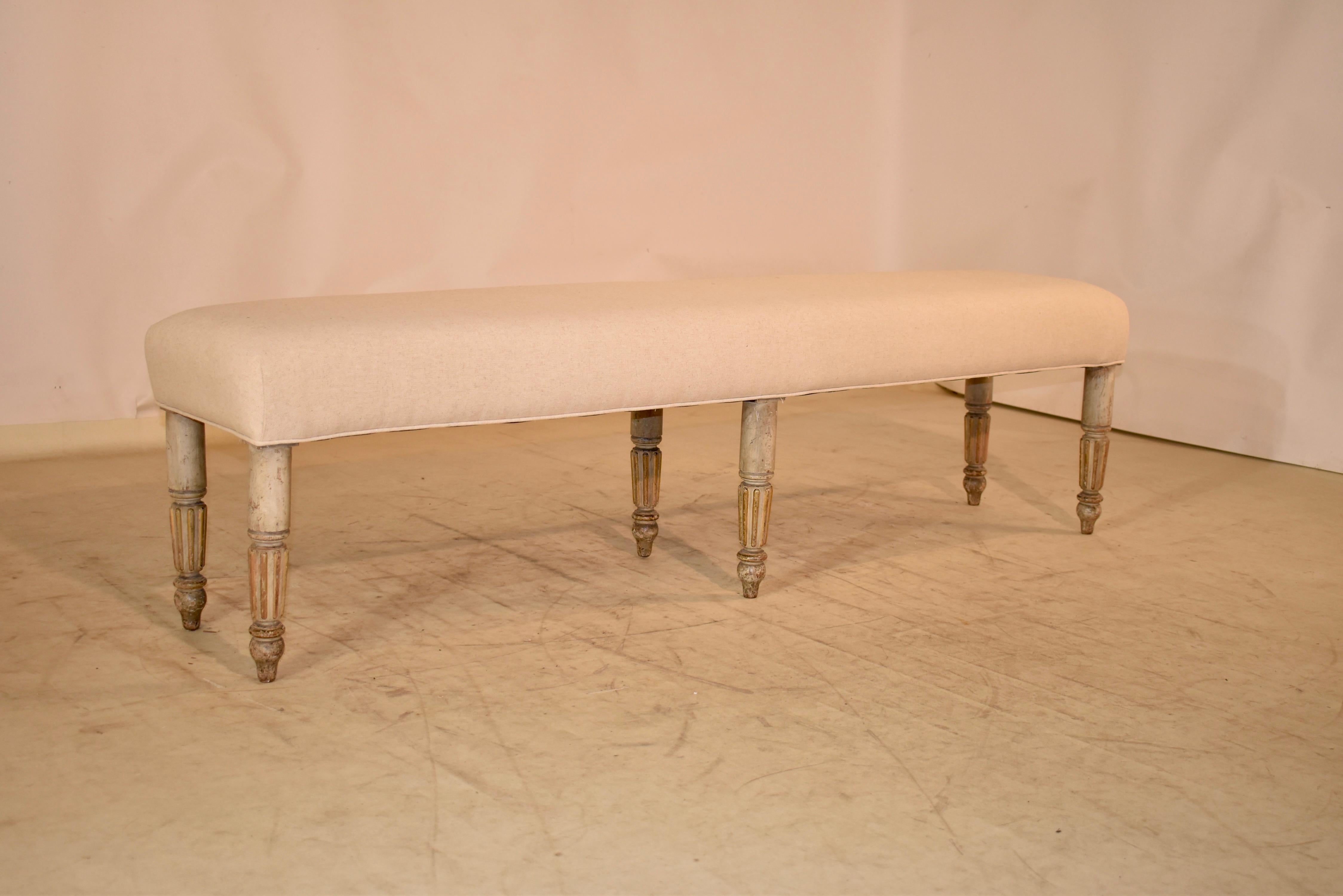 Earl 19th century Louis Philippe I bench made from fruitwood and with the original paint finish.  The bench is supported on six hand turned and reeded legs, ending in tall hand turned feet.  The seat of the bench has been newly upholstered in linen
