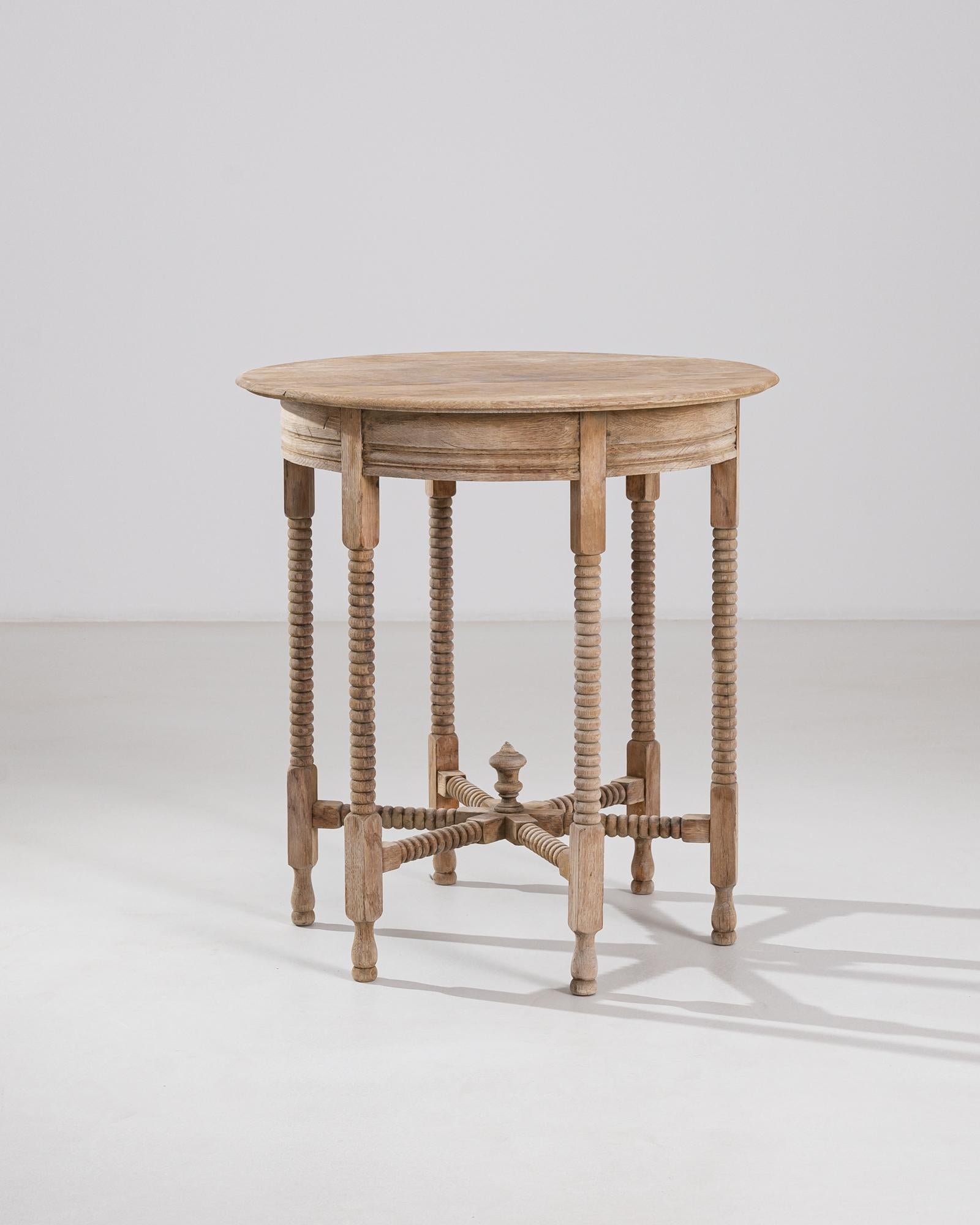 Crafted at the turn of the 19th century, this elegant piece was made in France. Turned legs are grouped in eight, ringed with a curved apron and interlocked below, the intricate geometry multiplies the clean lines of the piece’s silhouette. The wood