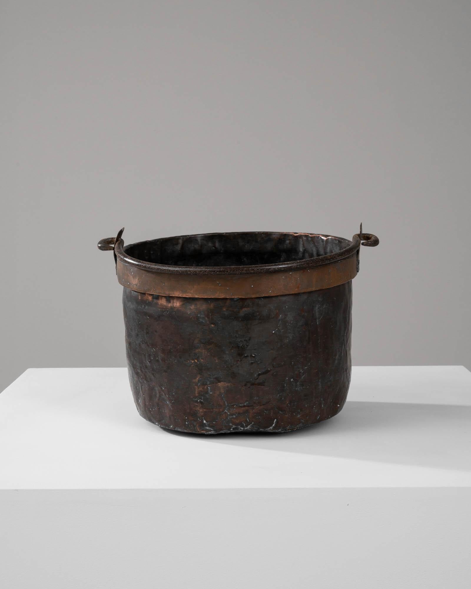 Unearth the rustic allure of this Early 19th Century French Brass Bucket, a striking testament to enduring craftsmanship. This robust container has been forged from brass, a material prized for its resilience and distinct golden hue that has now