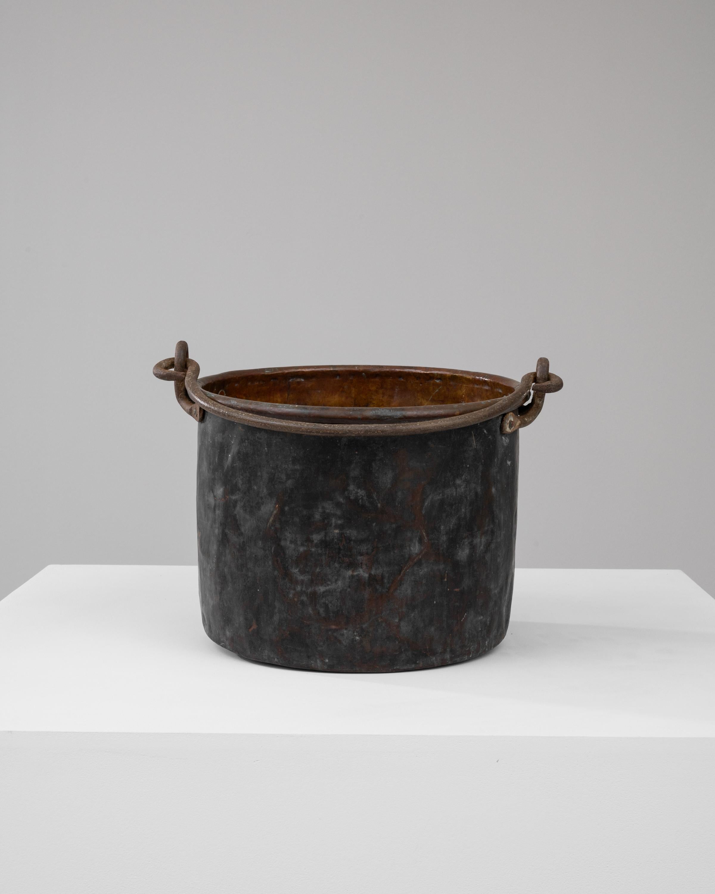 Imbued with the essence of the early 1800s, this French Brass Bucket is a tangible piece of history. The burnished surface, etched with the marks of time, reflects the many hands it has passed through and the myriad tasks it has performed. A sturdy,