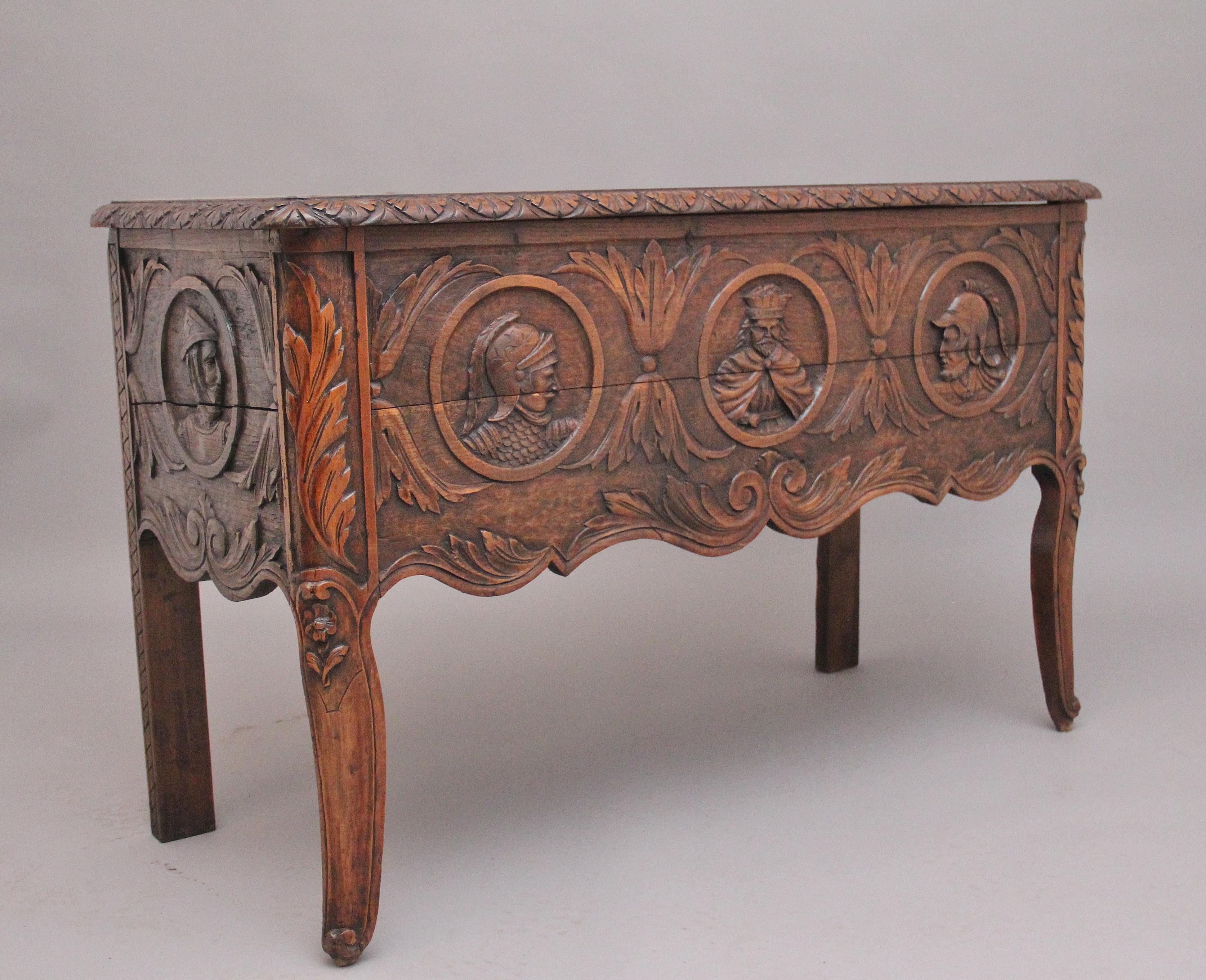 Early 19th Century French carved oak coffer, having a nice figured top with a decorative carved moulded edge, which opens up to reveal a large compartment space with a removable sloping plank, the front and sides of the coffer having carved floral