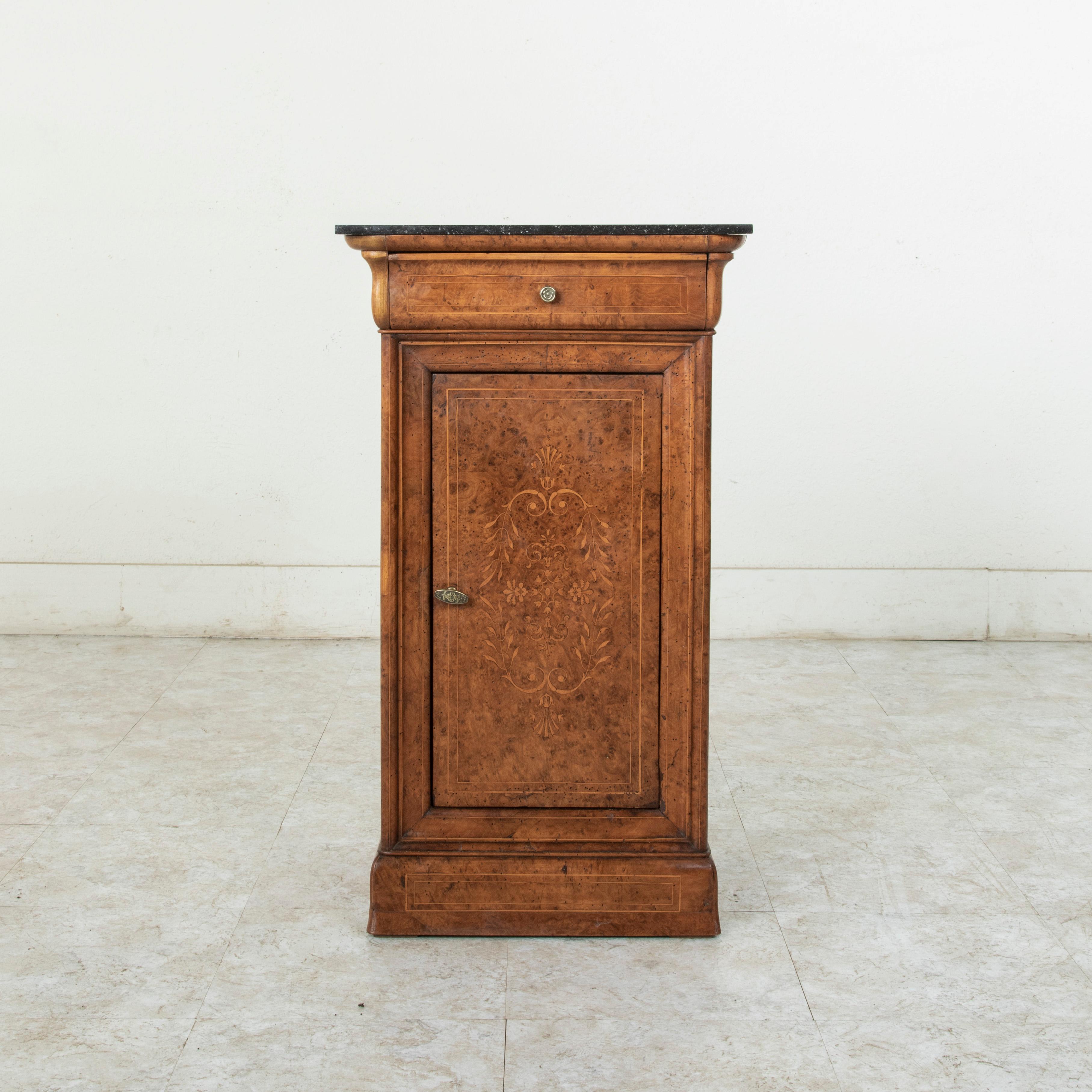 This early 19th century French Charles X period cabinet features a facade constructed of bird's-eye maple with fine lines of inlaid lemon wood that create an inset border around each face. A single drawer beneath its black marble top fits seamlessly