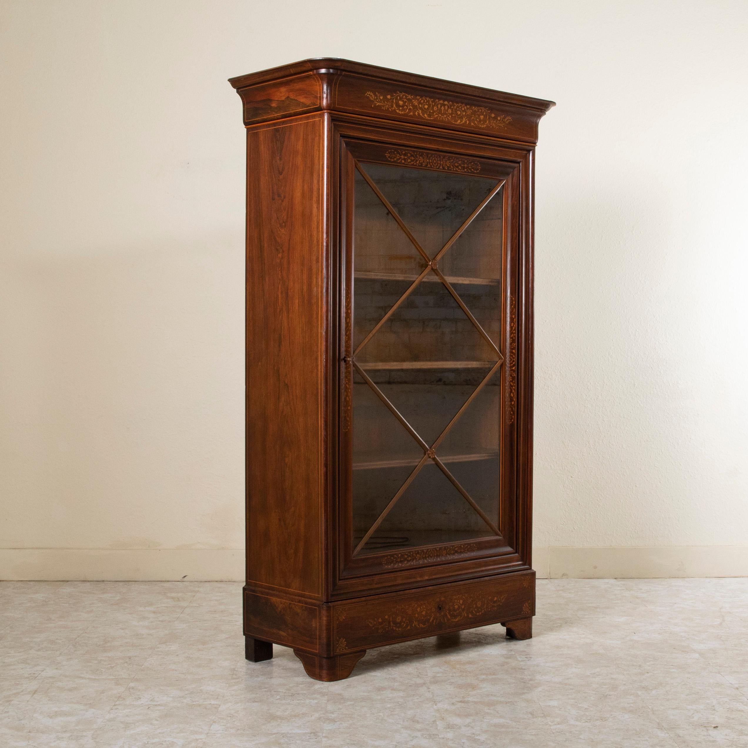 A unique piece from a short period of time in French furniture making, this early nineteenth century French Charles X period mahogany vitrine or bookcase features fine lines of lemon wood inlay outlining the face and each side of the cabinet.