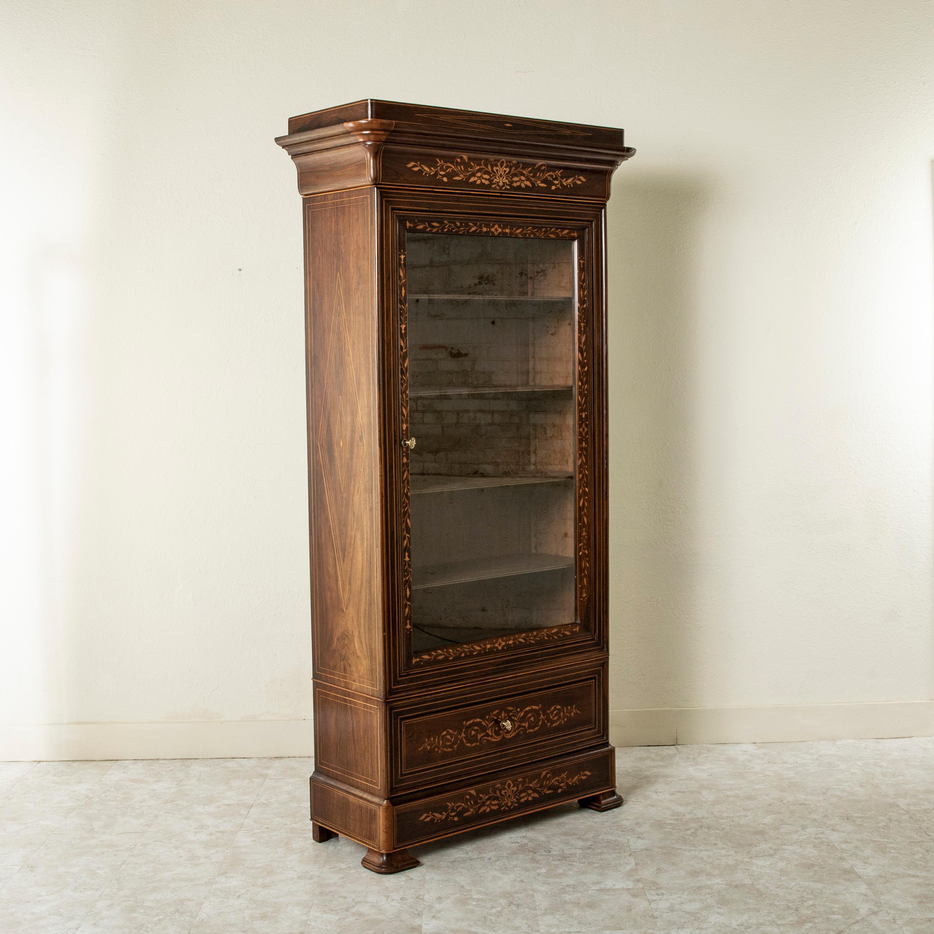 A unique piece from a short period of time in French furniture making, this early nineteenth century French Charles X period palisander vitrine or bookcase features fine lines of lemon wood inlay outlining the face and each side of the cabinet.