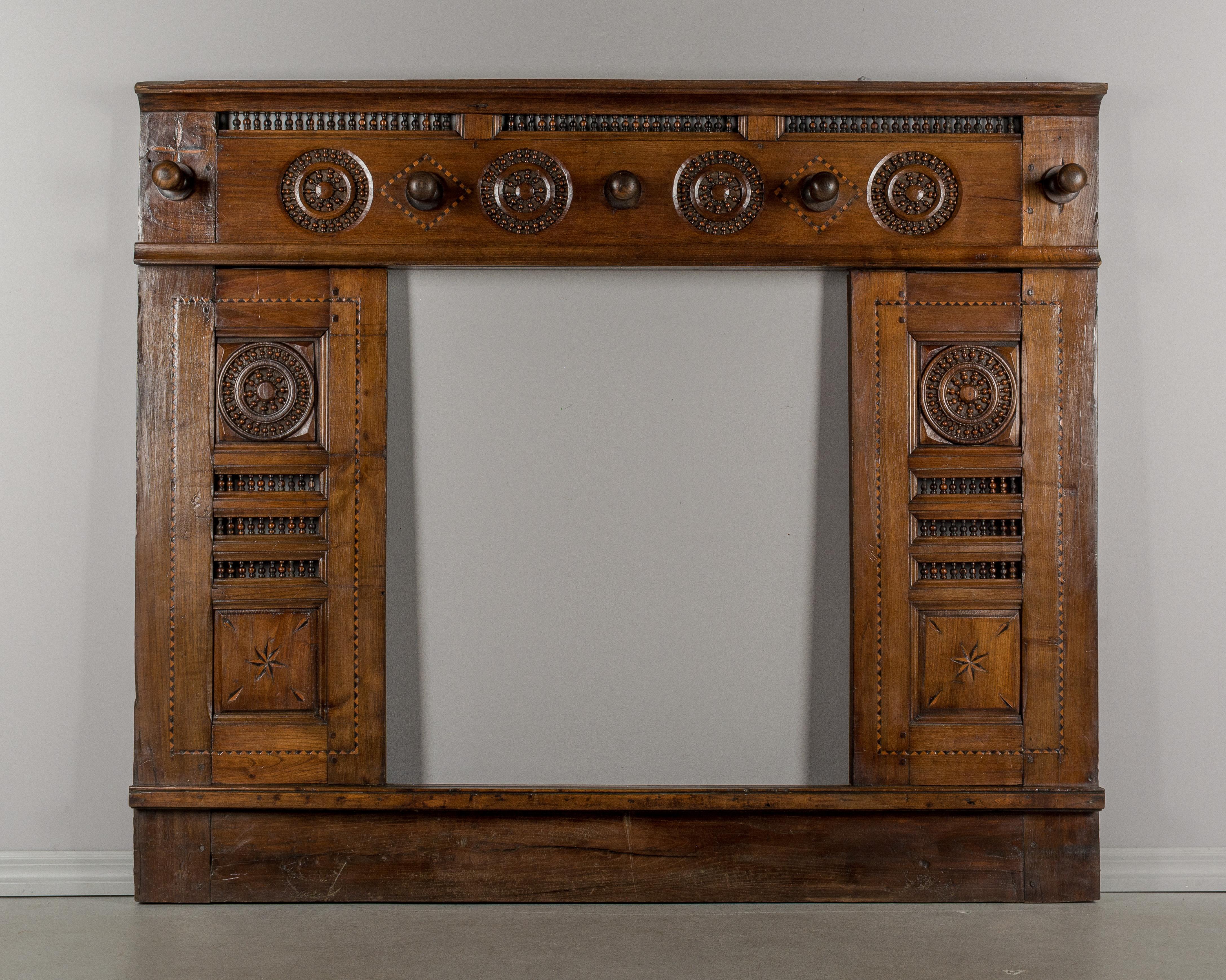 An early 19th century French hall tree made of chestnut. This was originally the front framework of a traditional Brittany lit clos (enclosed bed). The cabinet doors have been removed and five large pegs were added at the top to hang coats and hats.