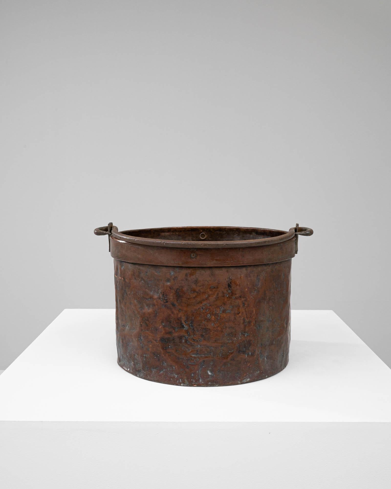 Step back in time with this authentic Early 19th Century Copper Bucket, a testament to enduring craftsmanship and vintage charm. Each inch of its weathered surface tells a story of years gone by, from the rich patina on the copper banding to the