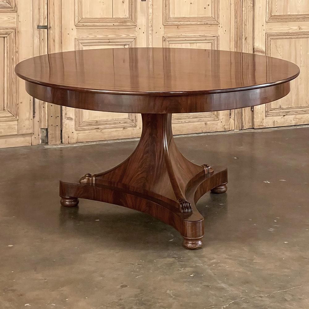 Early 19th century French Directoire mahogany center table is a stunningly well-preserved example of the neoclassic-inspired design that occurred in France right after the demise of Napoleon Bonaparte. The tailored architecture of the Empire design