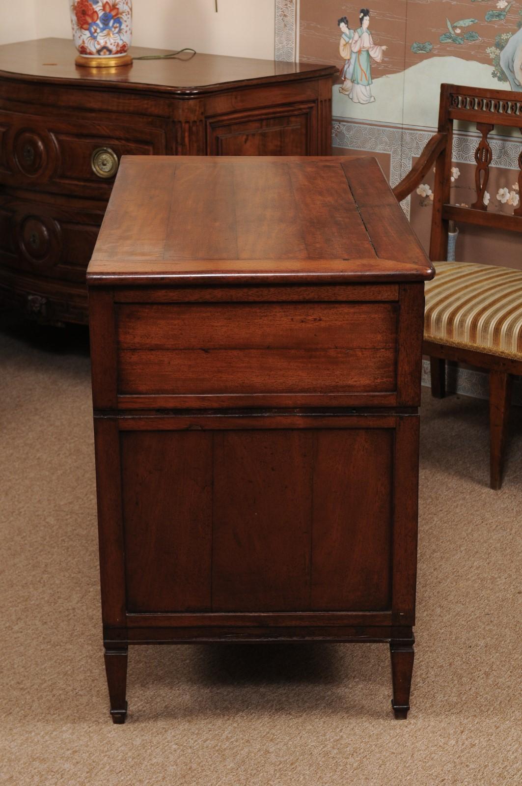 The early 19th century French Directoire commode in walnut with rectangular top, 3 drawers and turned tapered legs. 

  