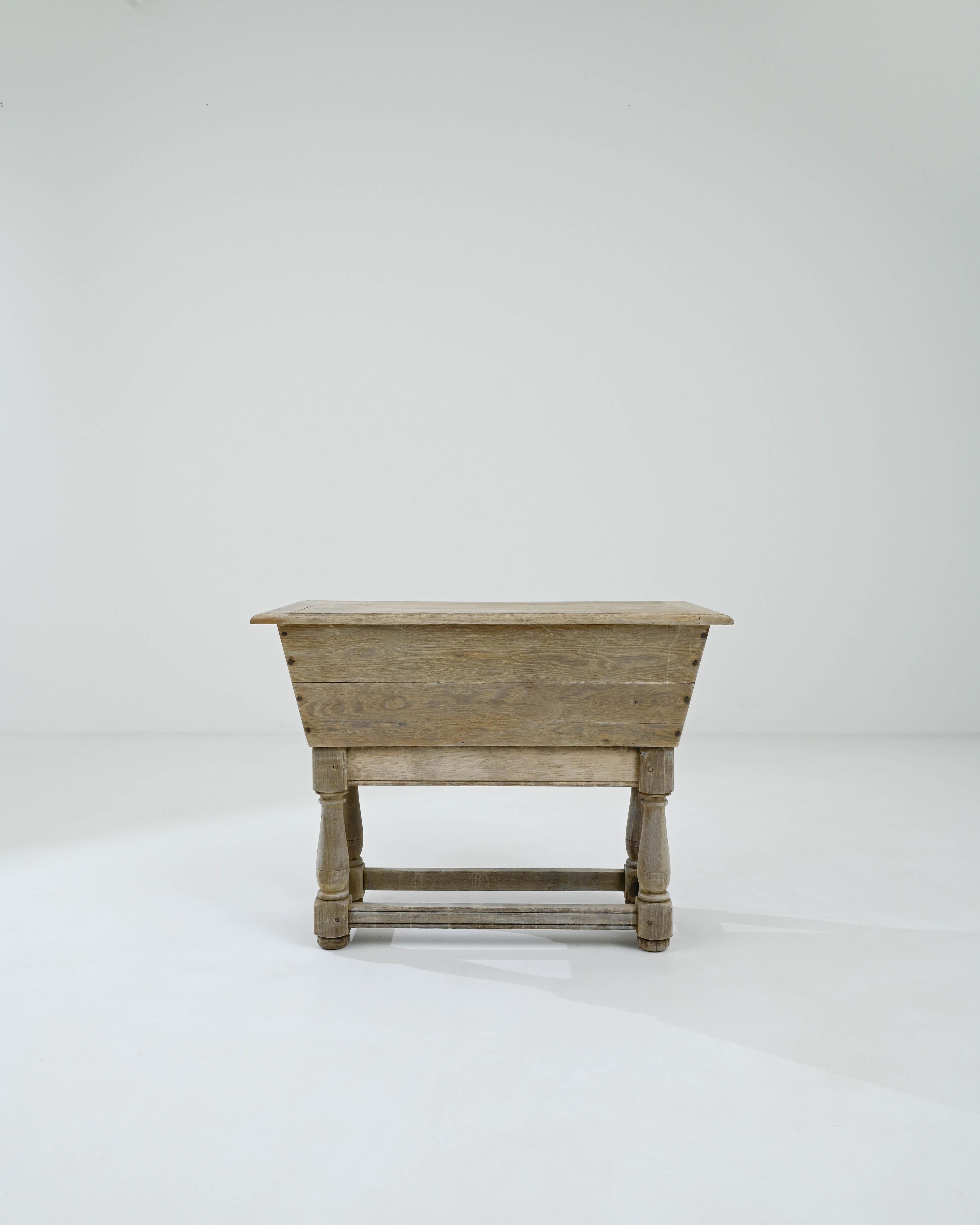 Handsome and versatile, this antique oak side table combines provincial simplicity with warm natural finish. Hand-built in France in the early 1800s, the rectangular tabletop sits atop a deep storage compartment, originally used for storing rising