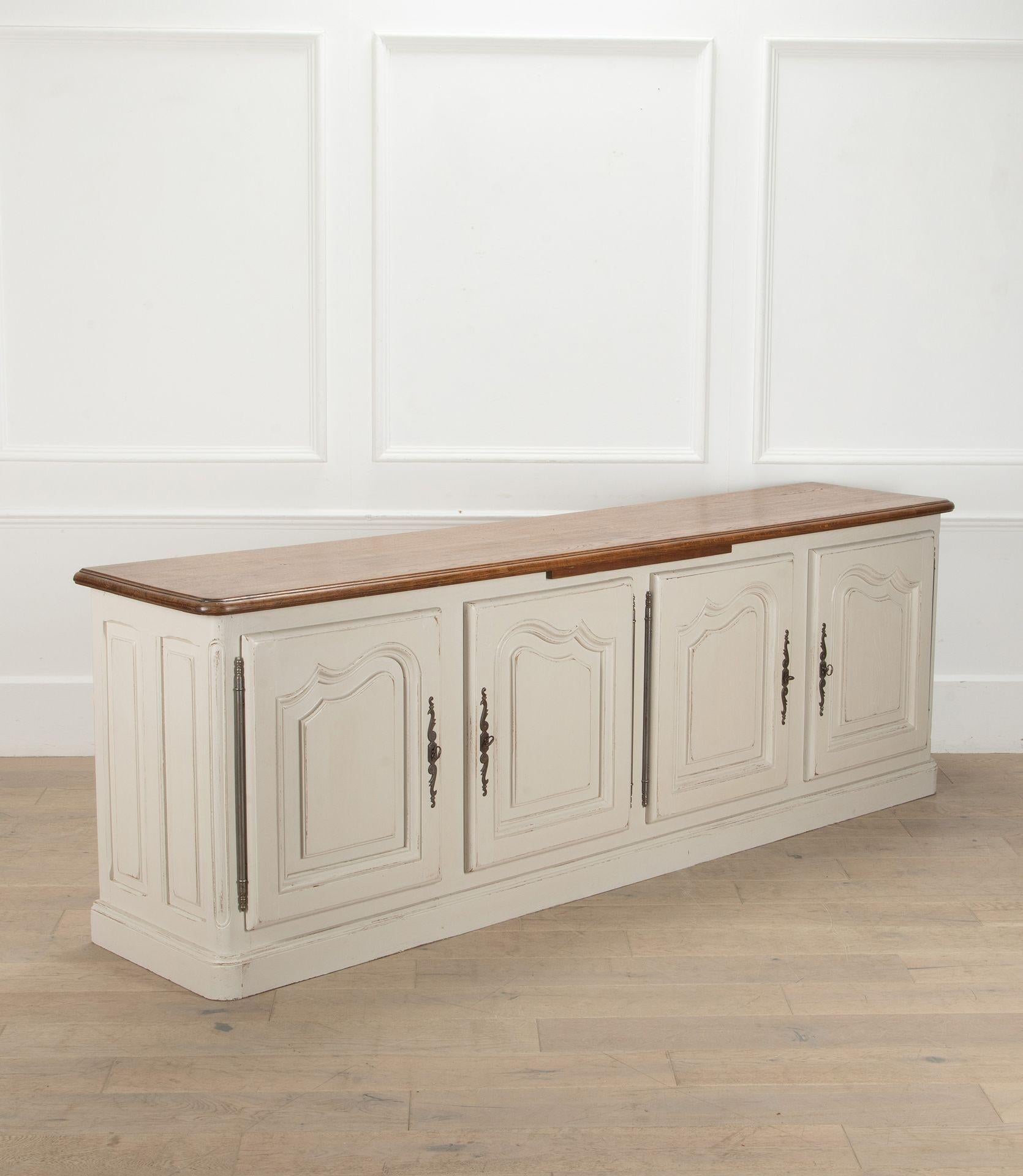 Early 19th Century French dresser base.
Wonderfully panelled with two shelves and two drawers inside. With an oak top and bread slide underneath.